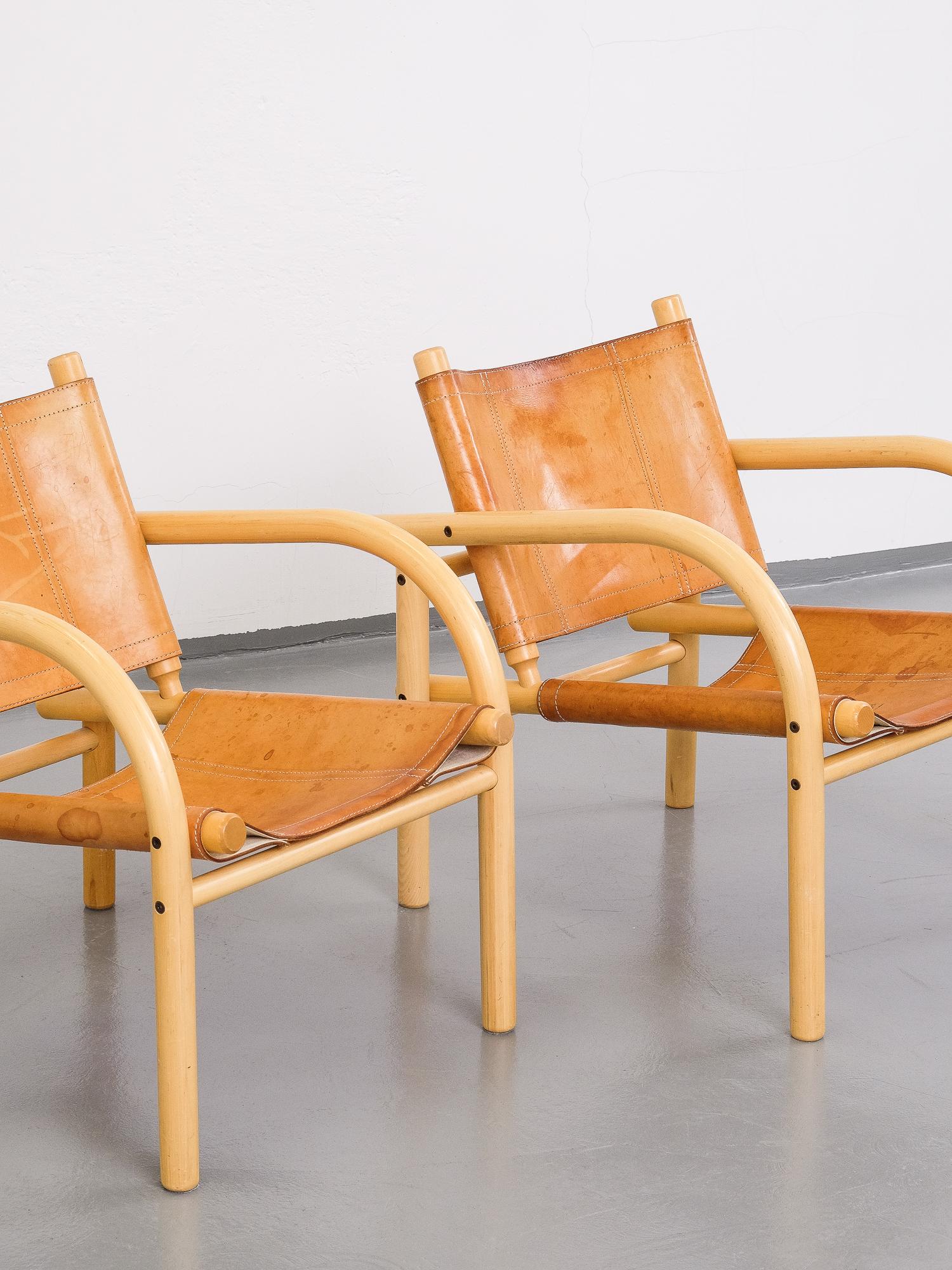 Pair of Classic safari chairs from Finland designed in 1974 by Ben af Schultén for Artek. Birch frame with seat and back in patinated natural leather. This is the bigger lounge chair model.