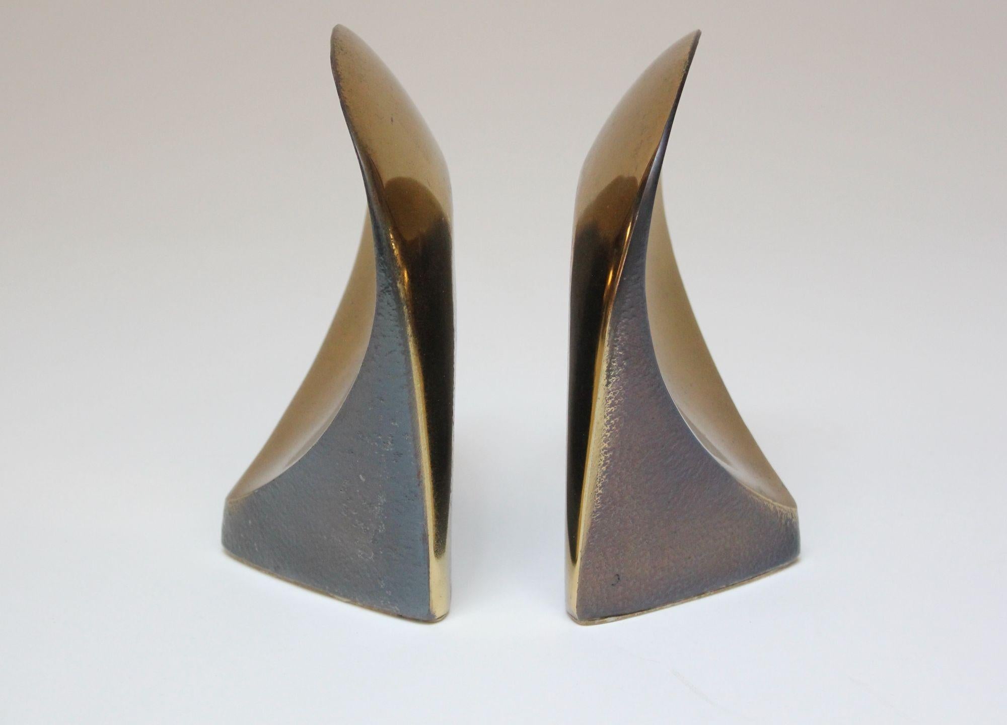 Pair of sculptural brass bookends Designed by Ben Seibel for Jenfredware.
Unique, scarcely seen examples incorporating a two-tone, textured design (there are blackened areas which are mottled, providing a dense texture and color contrast to an