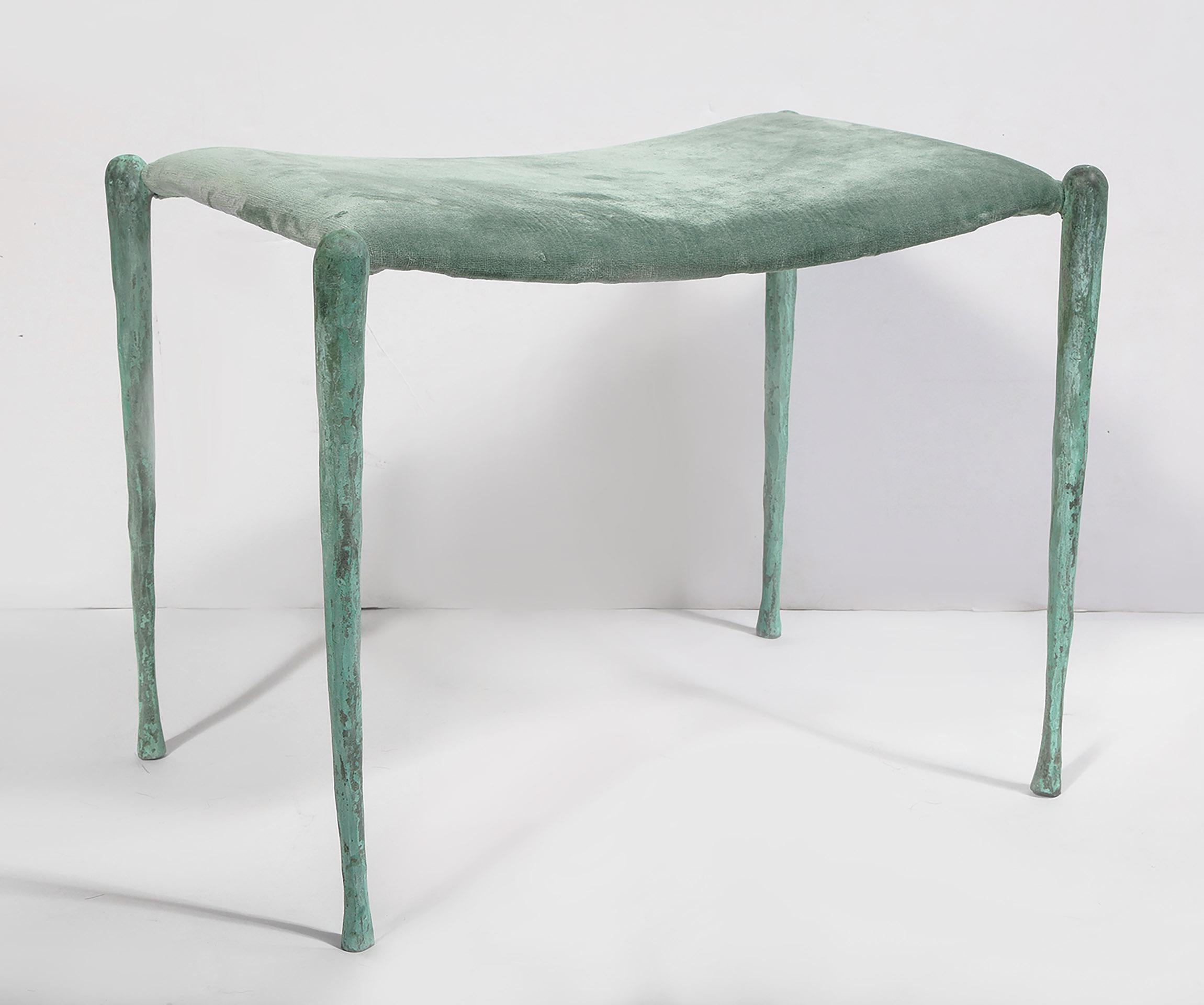 Zwei handgefertigte Bänke aus patinierter Bronze, jeweils mit gepolsterter Sitzfläche.
