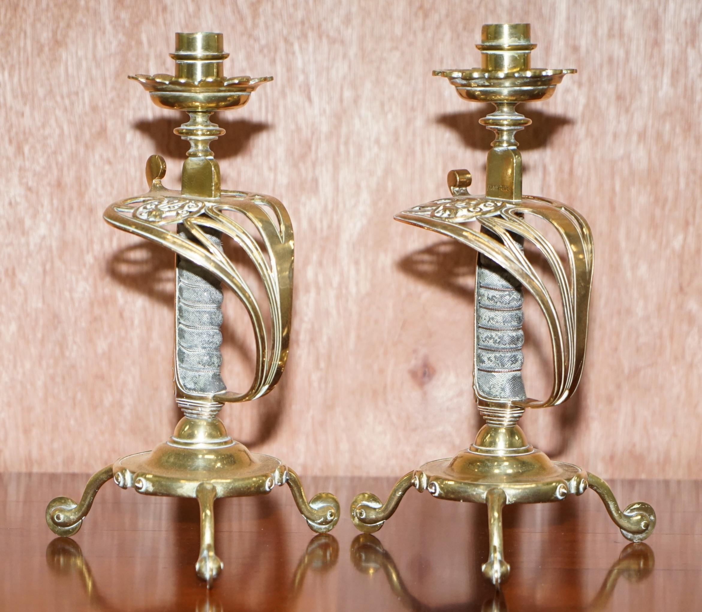 We are delighted to offer for sale this lovely pair of original 1905 British Army Sword handle brass and leather candlesticks by Benham & Froud

Benham & Froud circa 1855-1924, Chandos St, London, describing themselves variously as general metal