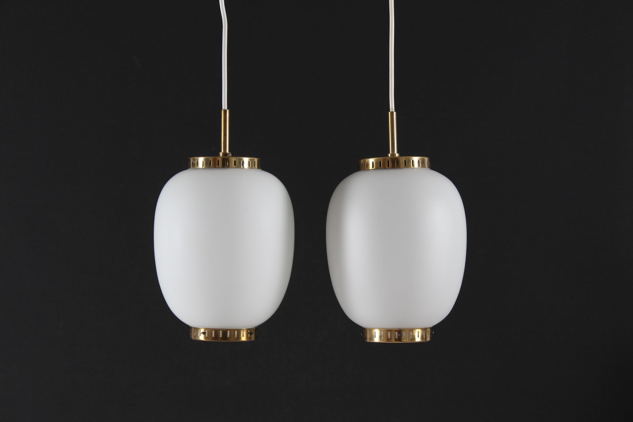 Pair of two China pendants (small version) made of off-white opaline glass with brass fittings. 
The pendants are designed by Danish Bent Karlby (1912-1998) and manufactured by the Danish lamp company Lyfa, Copenhagen in the 1960s.

Height glass
