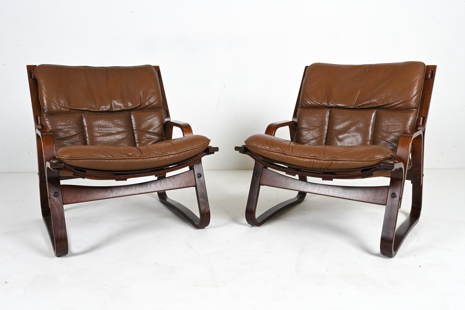 Live out your 1970's bungalow dreams with this rare pair of Norwegian Modern lounge chairs designed by Giske Carlsen for Kleppe Møbelfabrik. Crafted from bent beechwood, the sturdy frames are finished in a rich rosewood-mahogany stain, with