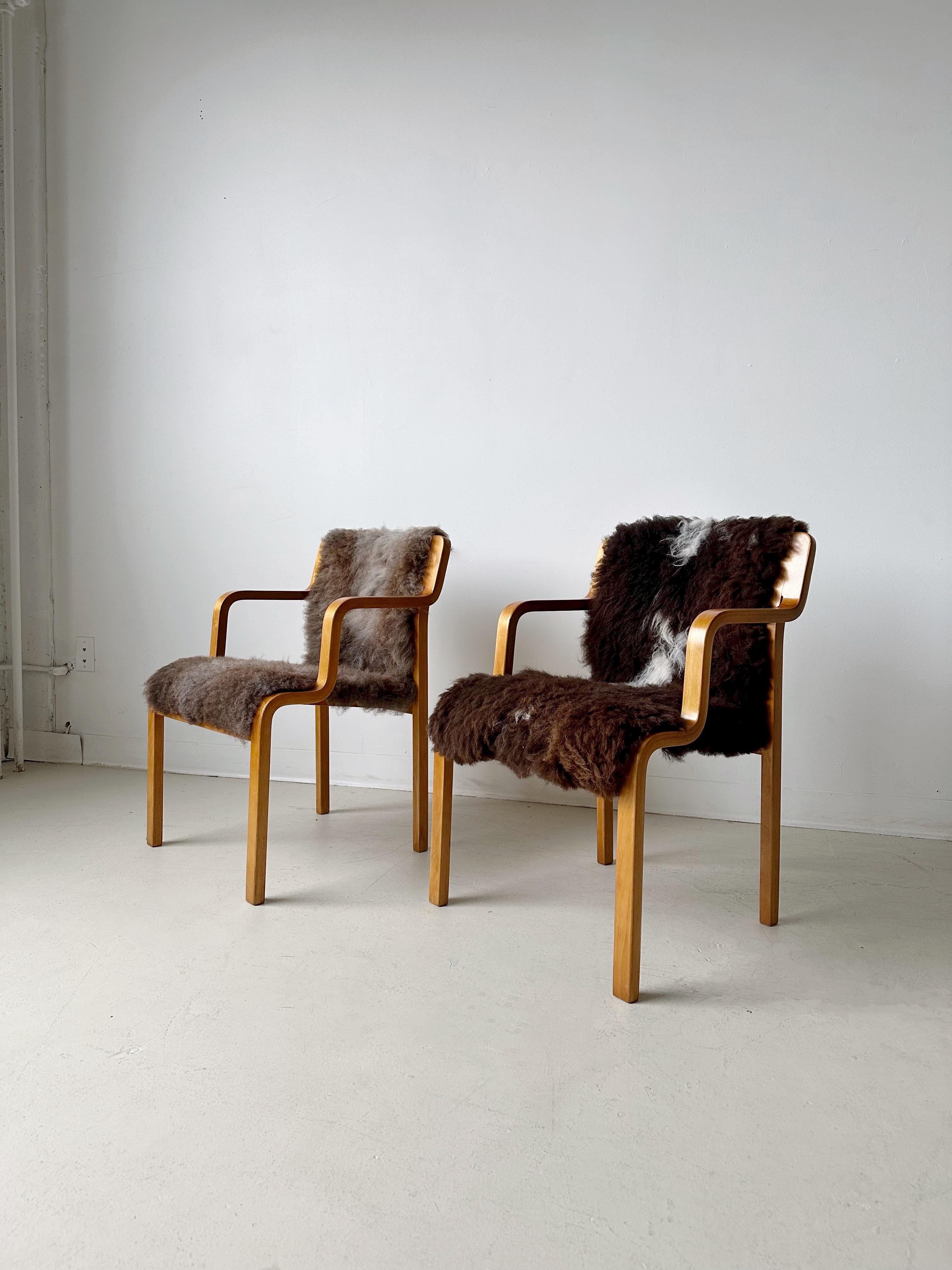 Pair of bentwood chairs by ASKO Finland, both reupholstered in sheepskin.

Like new condition.