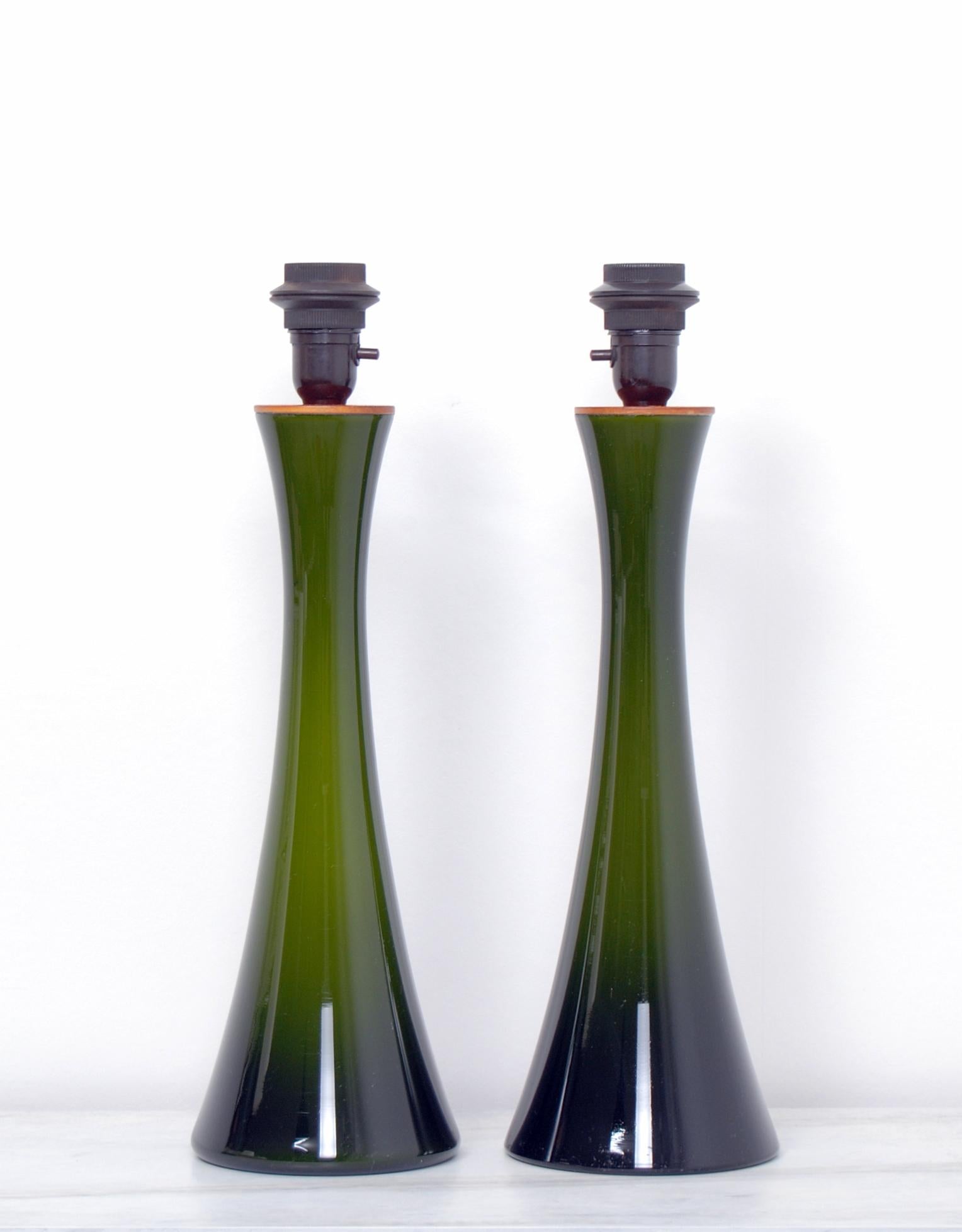 A pair of diabolo shaped Swedish green glass table lamps with teak fittings. Designed by Berndt Nordstedt for Bergboms. Newly rewired. For sale without the shades. The measurements and shipping costs stated are of the lamps without the shades.
  