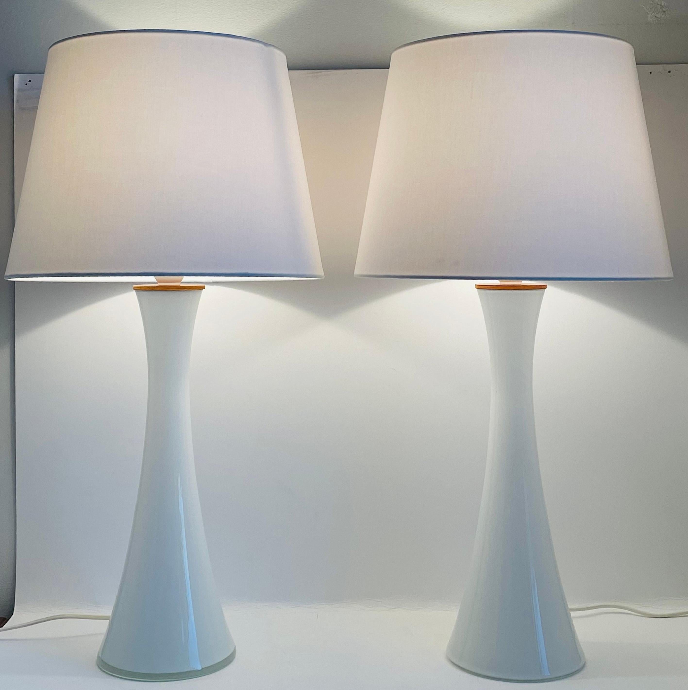 A pair of diabolo shaped Swedish milk white glass table lamps with teak fittings. Designed by Berndt Nordstedt for Bergboms. Please note: We are selling these lamps without the lamp shades. The measurements stated are of the lamps without the