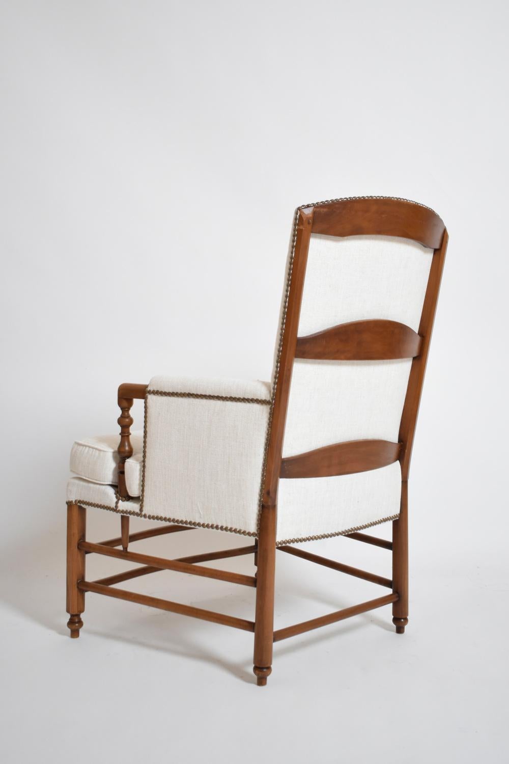 Paire de fauteuils bergère avec pieds et montants en bois. France, années 1950.