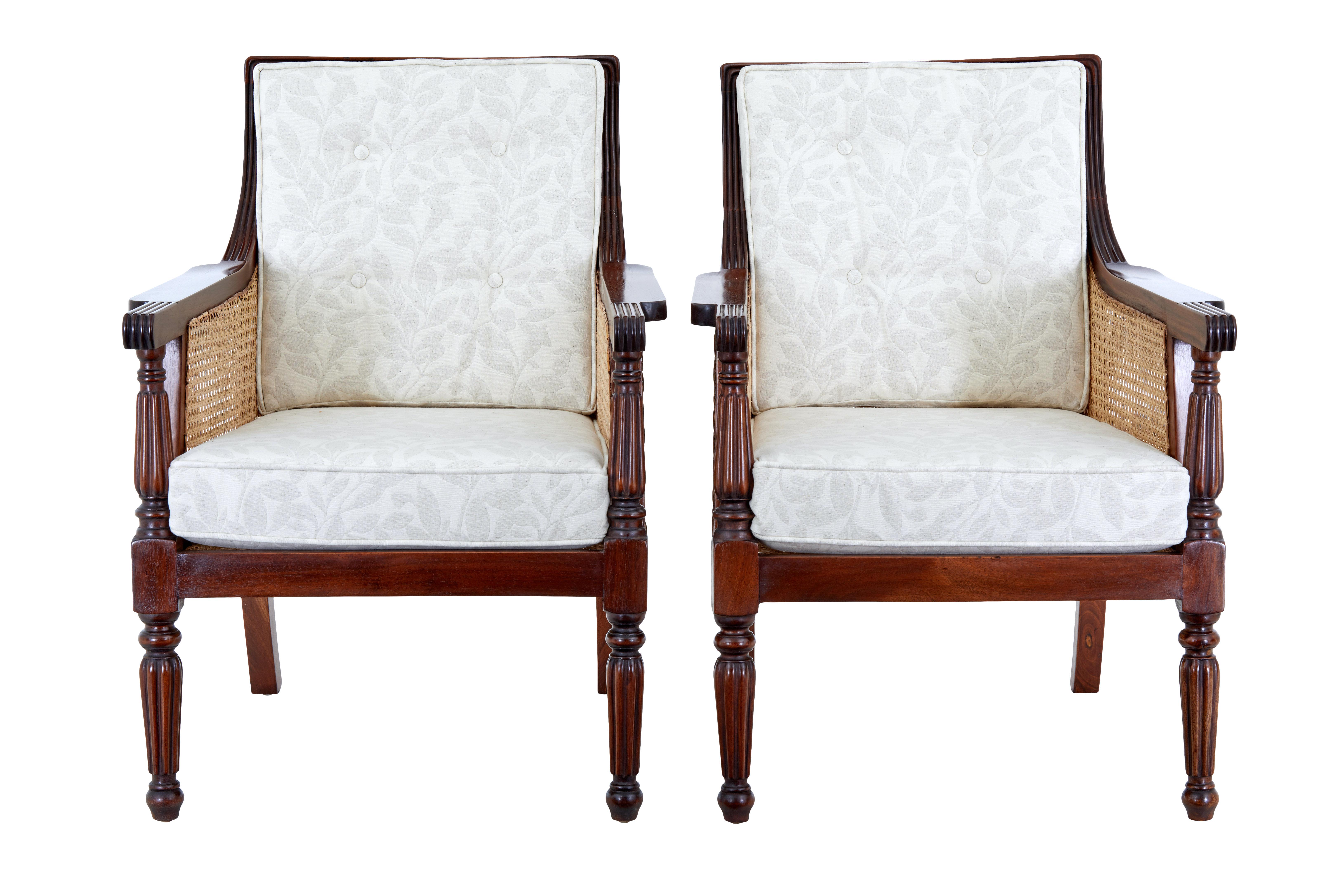 Pair of bergere cane work lounge chairs circa 1990.

Beautiful pair of regency inspired bergere armchairs presented in a rich polished mahogany.  Shaped backs, with turned supports and legs. Brand new padded seat and back rest