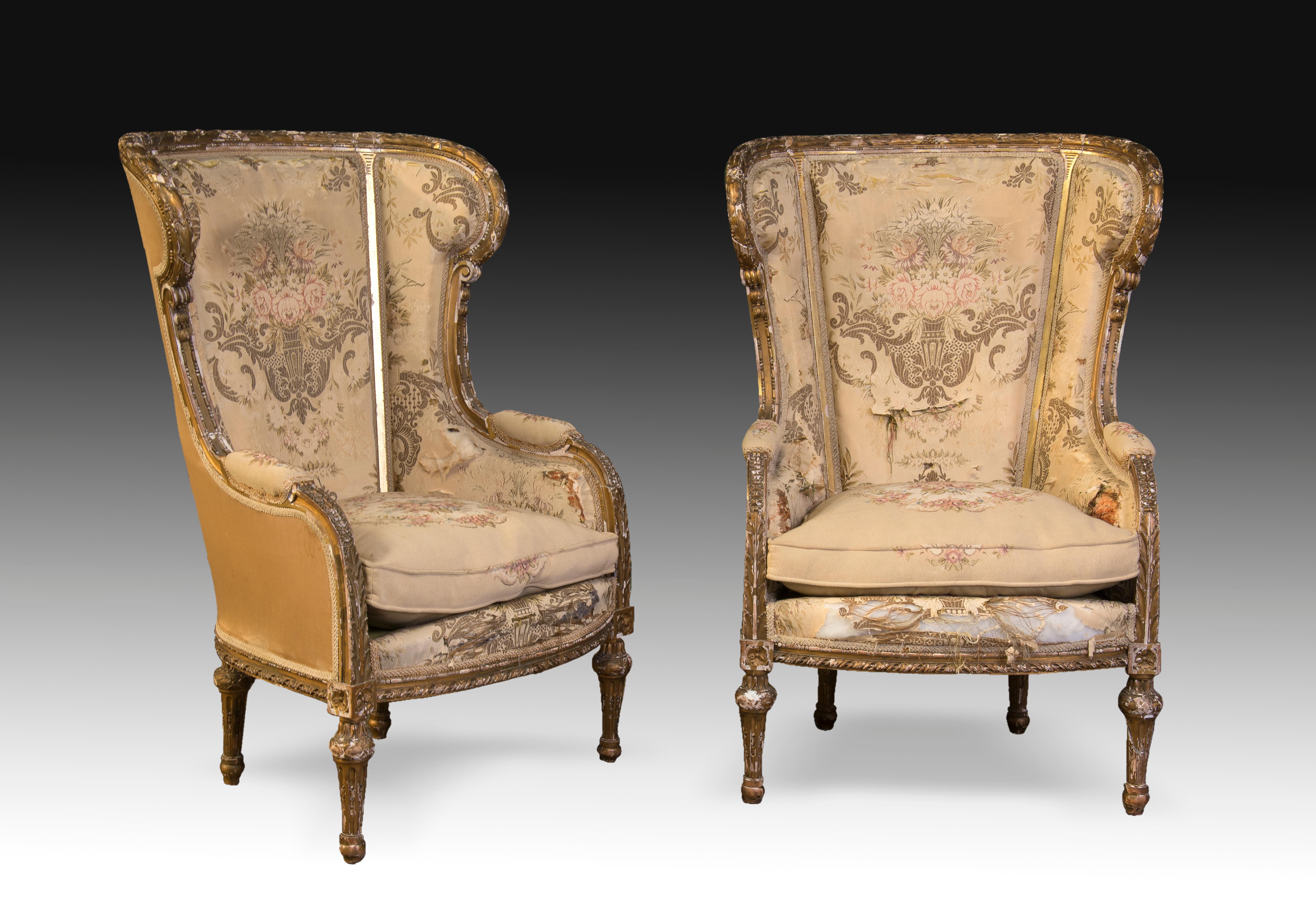 With marks.
They need restoration.
Pair of high-backed armchairs with armrests made of gilded carved wood that have an upholstery in light tones of plant elements accompanied by vases and architectural details of classicist influence. The forms of