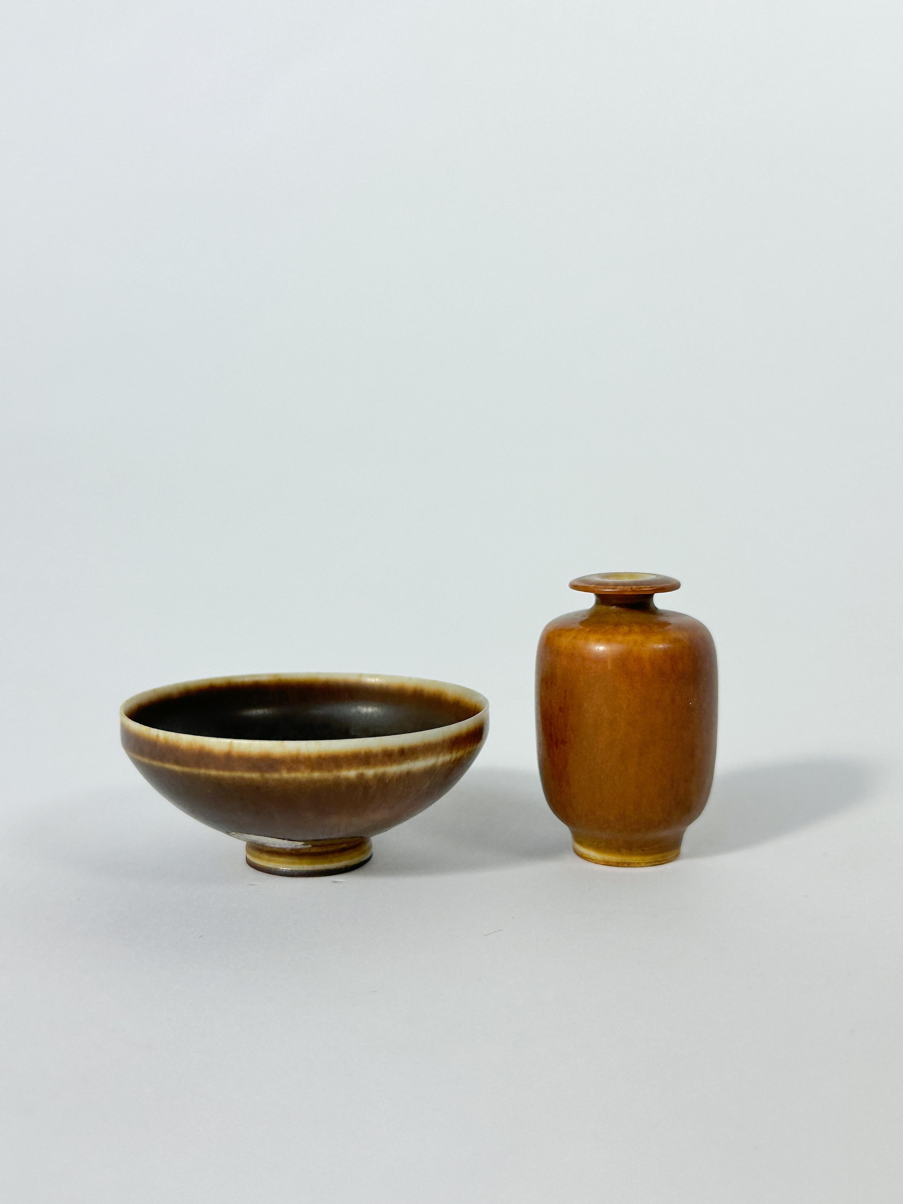 Ceramiche in miniatura dell'unico e solo Berndt Friberg. 

Realizzato a mano dal maestro nel suo studio di Gustavsberg in Svezia. 

- vaso smaltato marrone del 1965, altezza 4 cm

- ciotola marrone del 1957, diametro: 5,5 cm

Entrambi in perfette