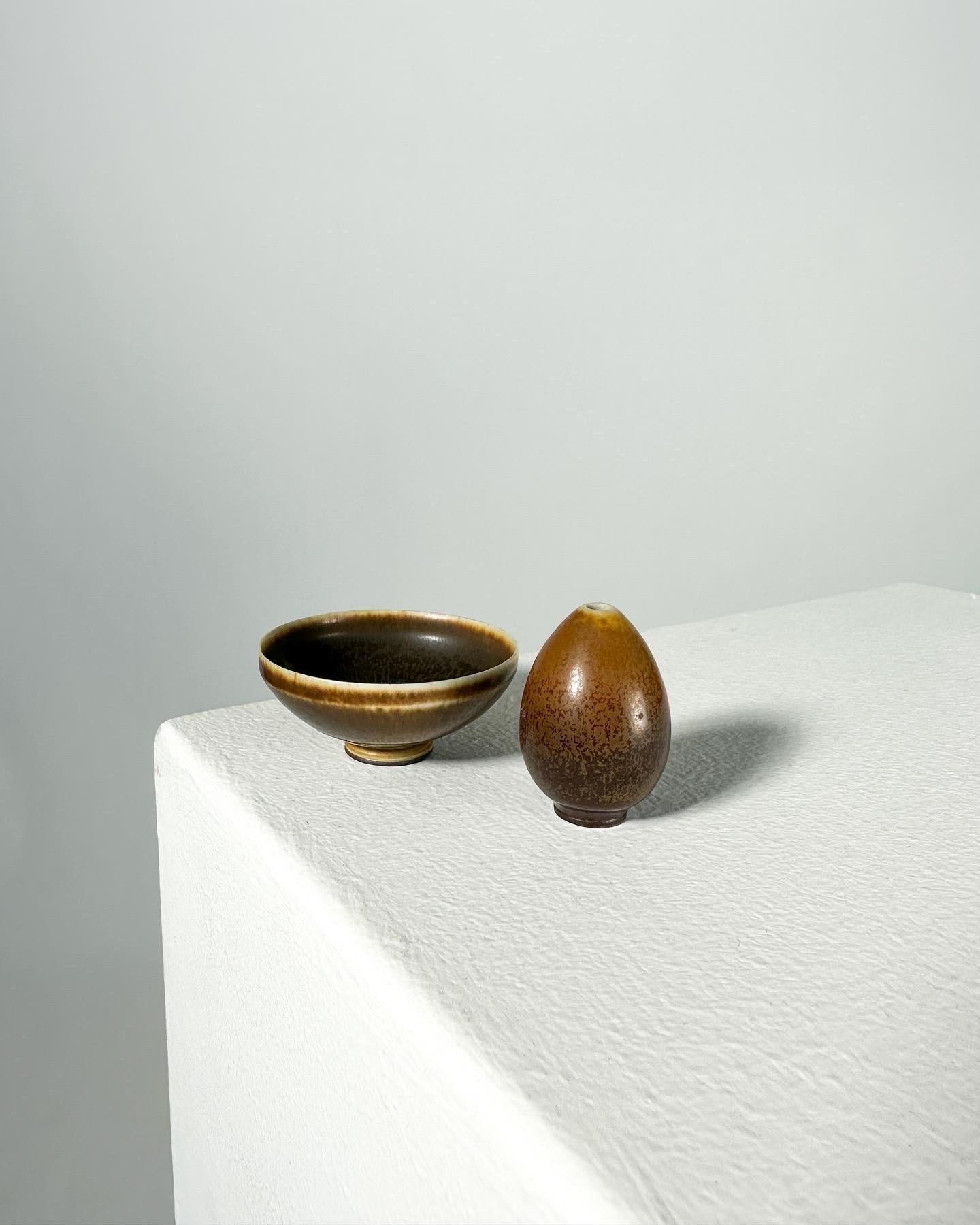Berndt Friberg miniature egg vase and brown bowl, hand-crafted at his studio at Gustavsberg factory in 1957.

Both in brown hare‘s fur glaze, signed with the letter „Ä“ which stands for 1957.

Diameter of bowl: 5.5 cm
Height of bowl: 2.3 cm
Height