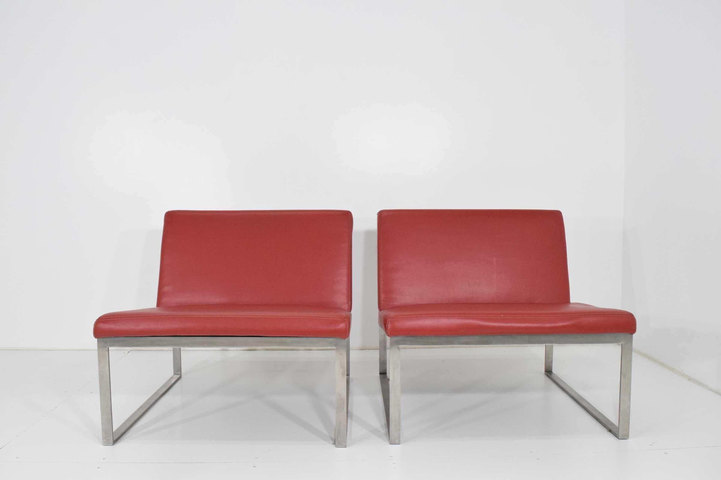 Chairs have an aluminum frame. Red vinyl upholstery. A few wear marks that can probably be expertly repaired if desired or chairs can be newly upholstered.