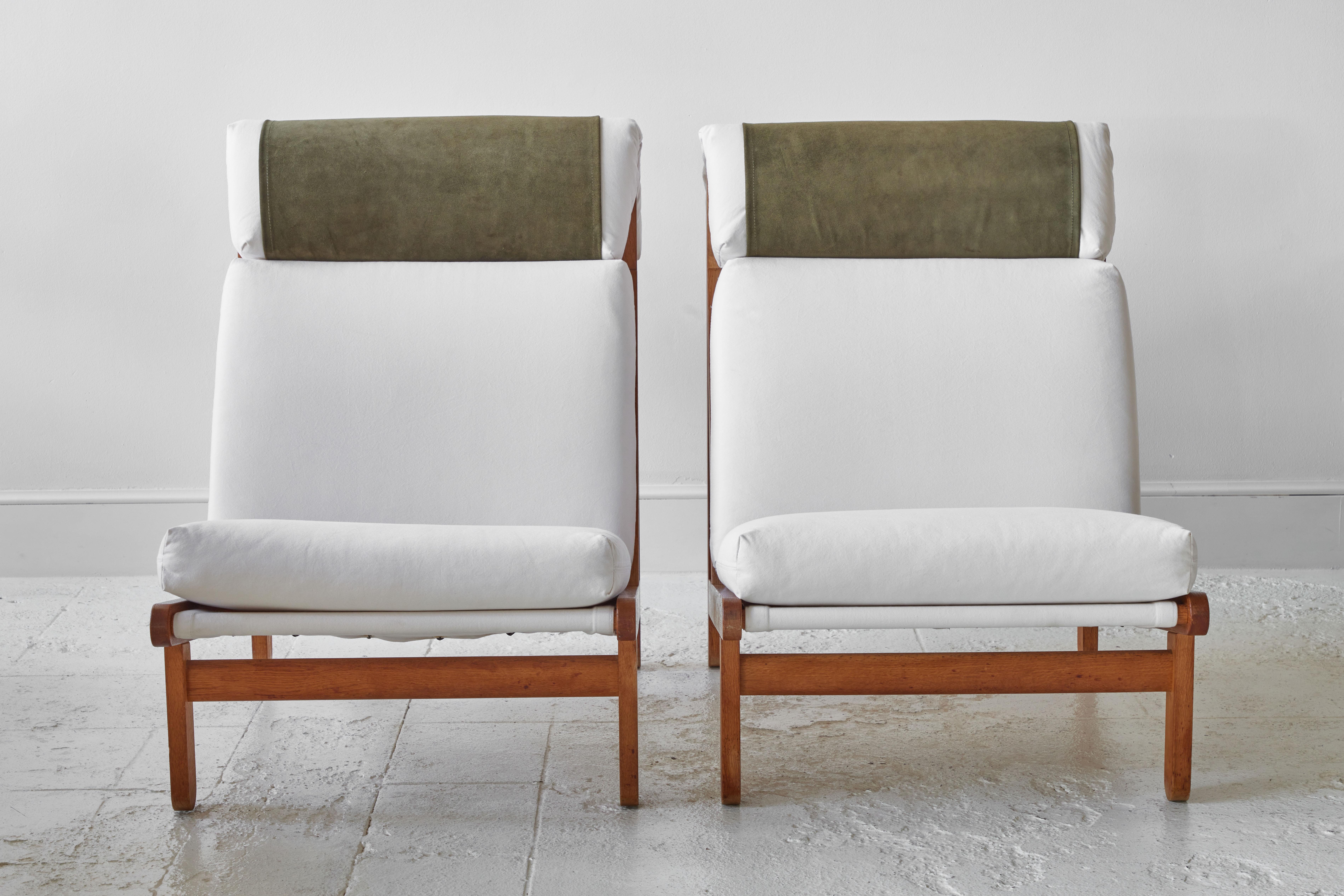 Rare and very sought after pair of easy lounge chairs designed by Bernt Petersen for Schiang Furniture of Denmark in 1966. Oak frame with loose cushions in seat and back upholstered with white cotton stone wash fabric. Neck-rest stretched with green