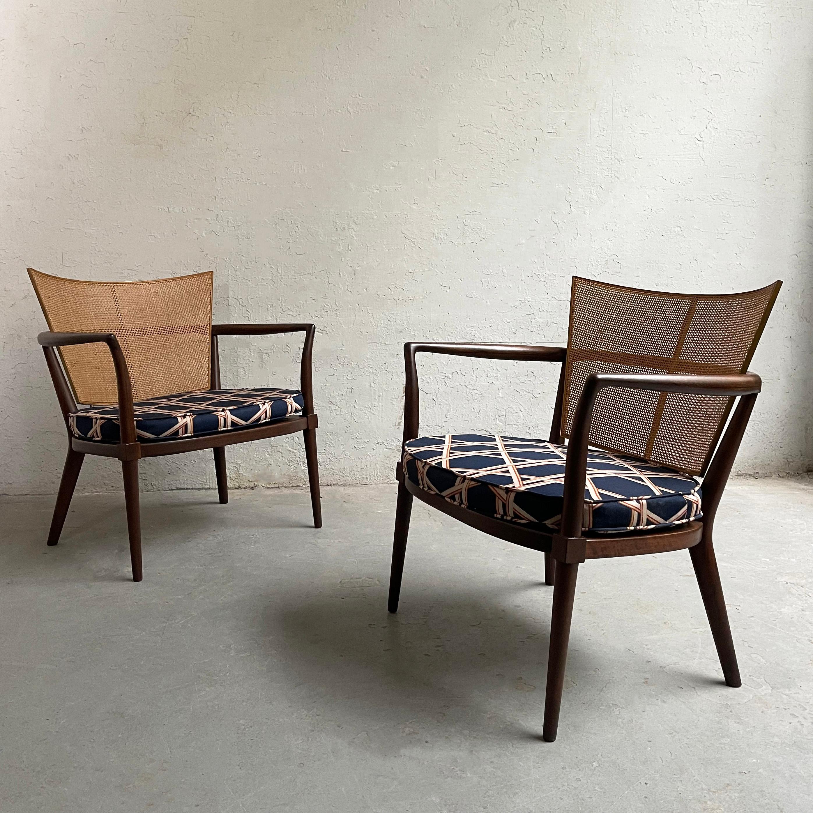 Pair of elegant, Mid-Century Modern armchairs by Bert England for Johnson Furniture feature slender, mahogany frames with brass trimmed, cane backs with newly upholstered cushioned seats. The arm height measures 22.5 inches.