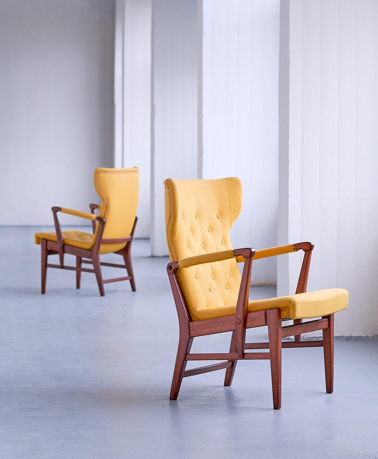 This rare pair of armchairs was designed by Bertil Söderberg and produced by Nordiska Kompaniet in Sweden in the 1940s. The elegant shape of the design is emphasized by the buttoned wing shaped back and seat. The mahogany frame is connected with