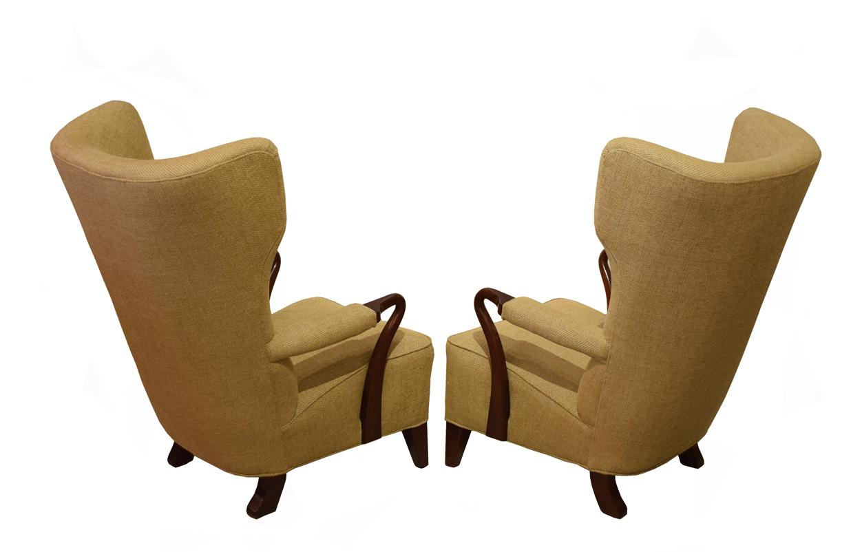 Great pair of Swedish Wingback armchairs by Swedish designer Bertil Söderberg, with curved arms in walnut-stained beechwood sculptural high back from 1930's.
Recovered in a gold-toned wool fabric.