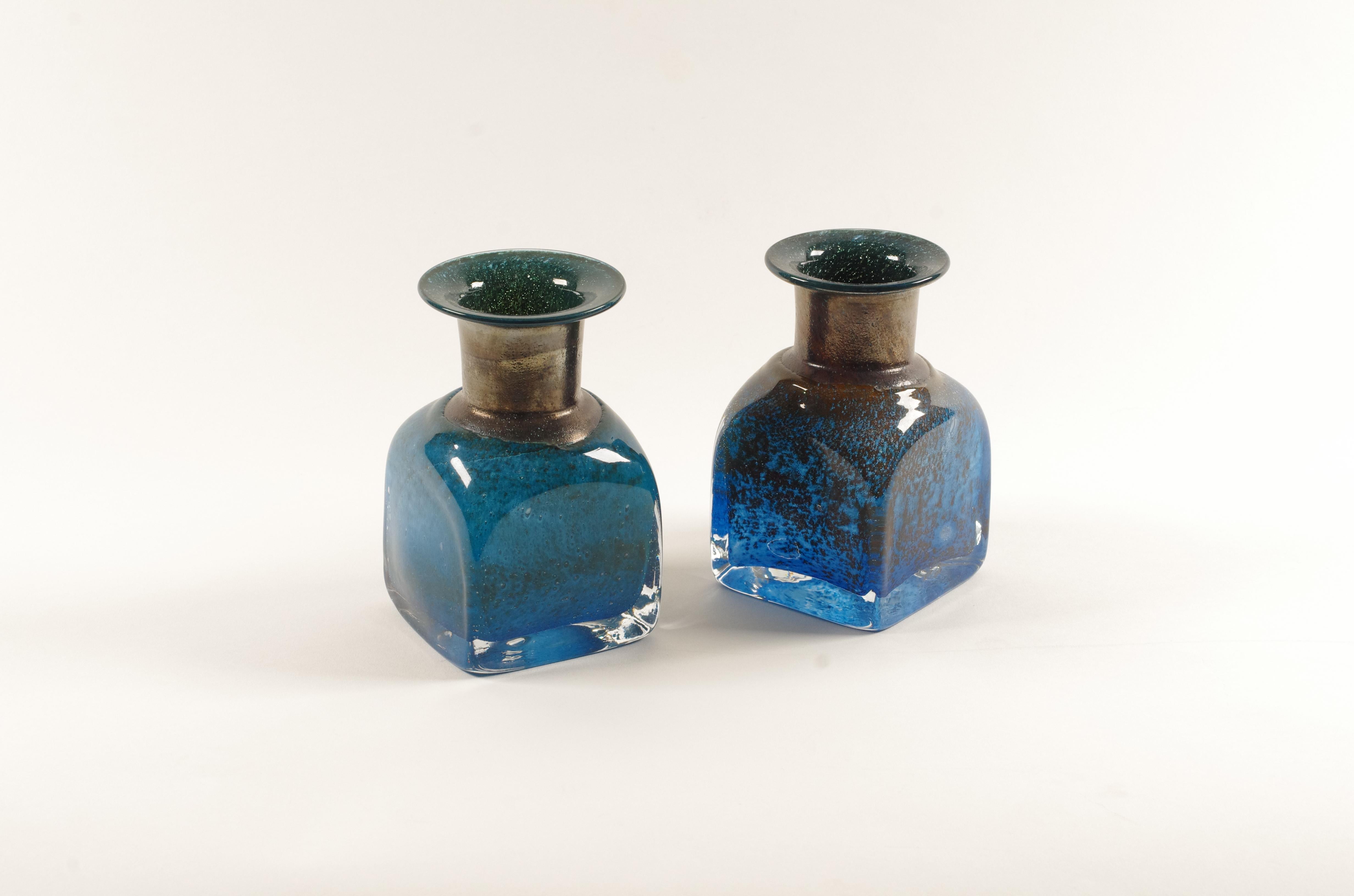 Coppia di vasi in vetro artistico soffiato a mano disegnati da Bertil Vallien per Boda (poi Kosta Boda), Svezia, modello 42703, prodotti alla fine degli anni 1960-1970.
Ogni vaso presenta la caratteristica forma a bottiglia quadrata di Vallien con
