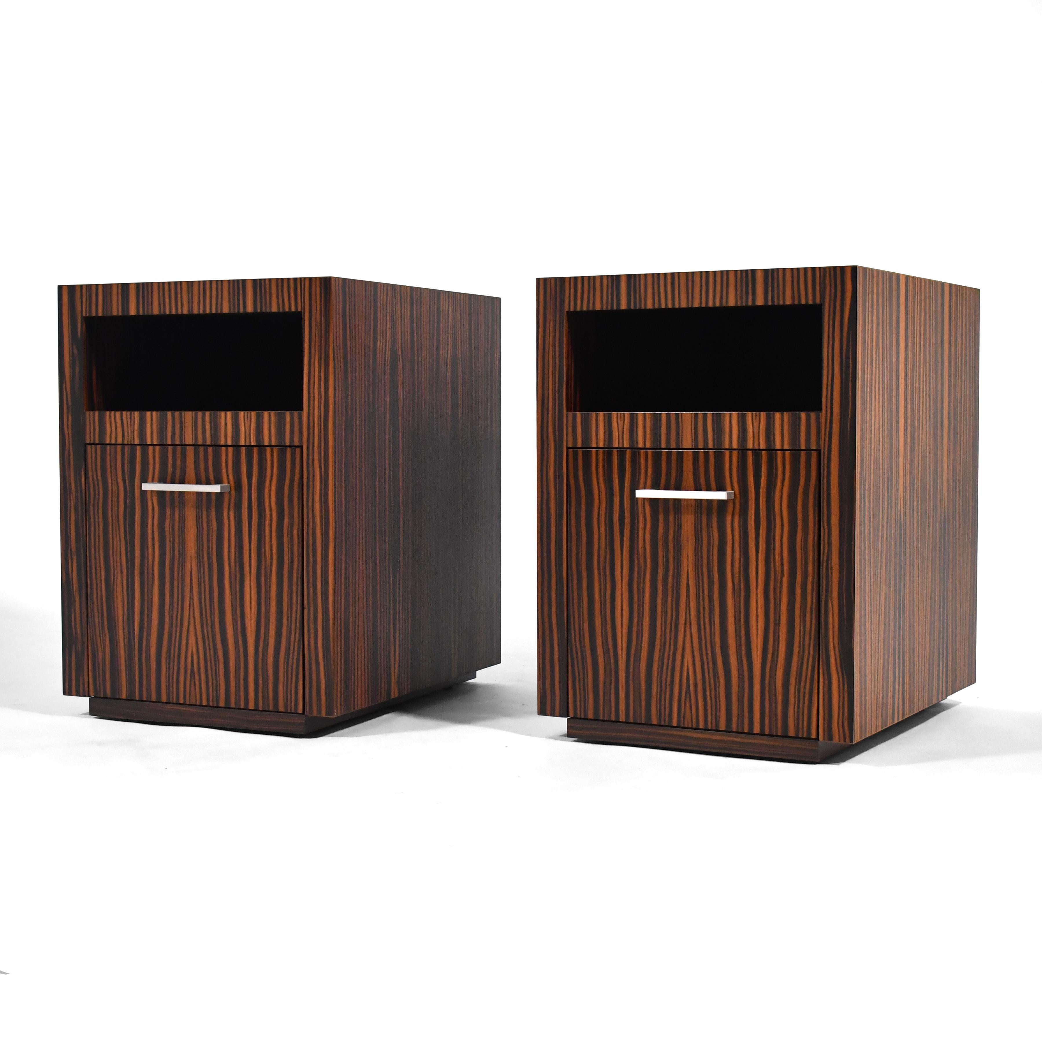 This spectacular pair of nightstands were custom designed by Richard Gorman and made by Manifesto in Chicago. The minimalist form is clad in rich, highly figured zebra wood and feature a storage compartment over a drawer with a sliding tray. They
