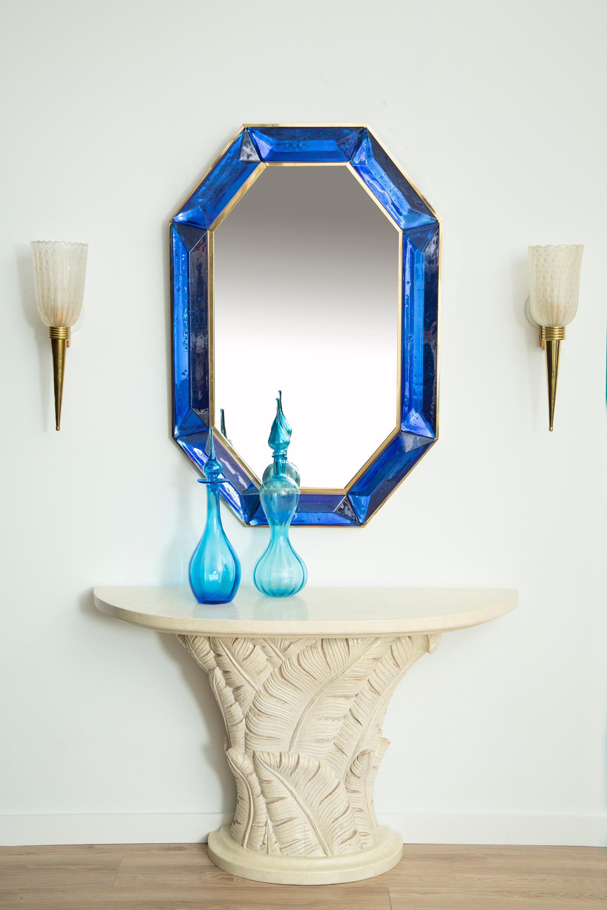 Pair of bespoke octagon cobalt blue Murano glass mirror, in stock
 Vivid and intense cobalt blue glass block with naturally occurring air inclusions throughout 
 Highly polished faceted pattern
 Brass gallery all around
 Each mirror is a unique