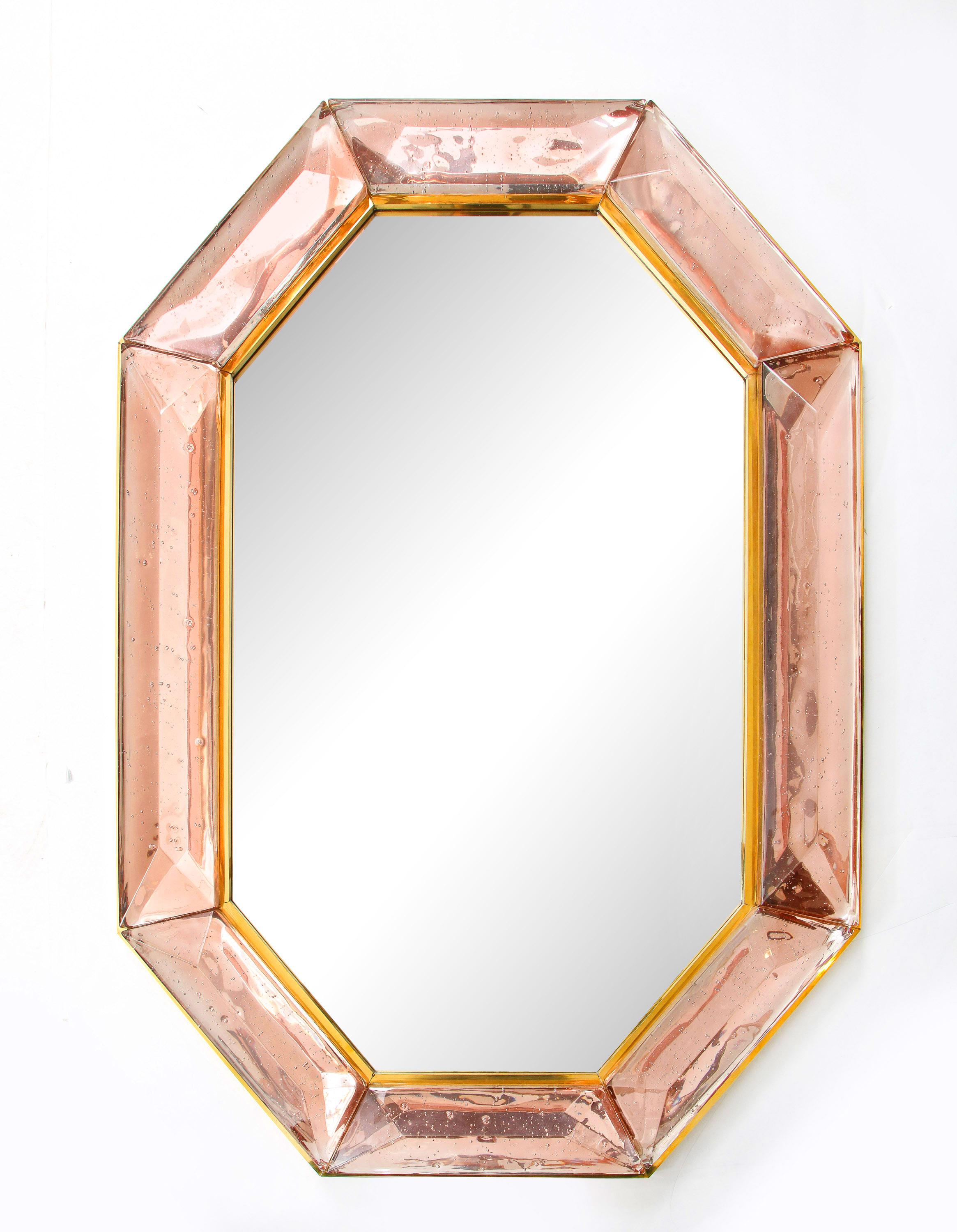Pair of bespoke octagon pink Murano glass mirrors, in stock
Vivid and intense pink glass block with naturally occurring air inclusions throughout
Highly polished faceted pattern
Brass gallery all around
Each mirror is a unique luxury handcrafted