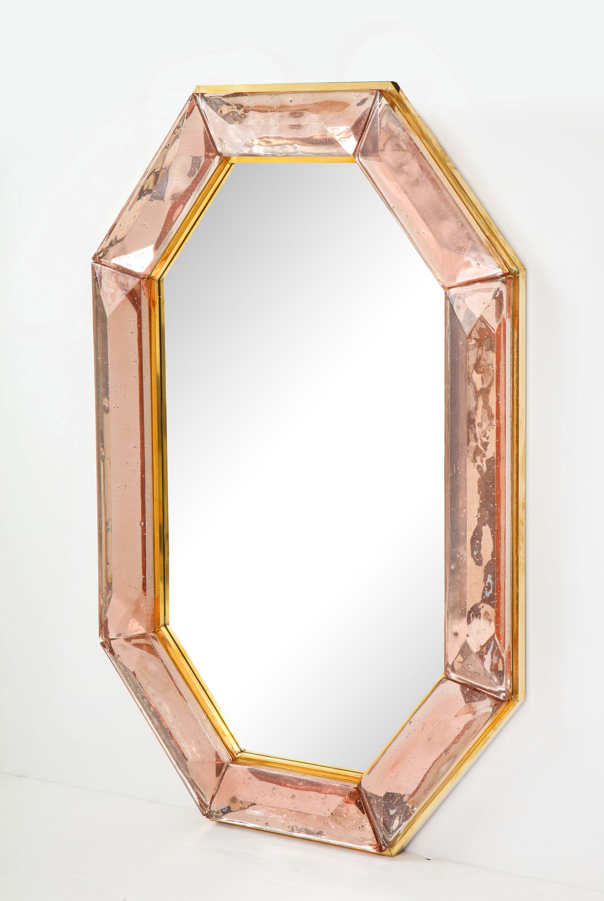Pair of bespoke octagon pink Murano glass mirrors, in stock
Vivid and intense pink glass block with naturally occurring air inclusions throughout
Highly polished faceted pattern
Brass gallery all around
Each mirror is a unique luxury handcrafted by