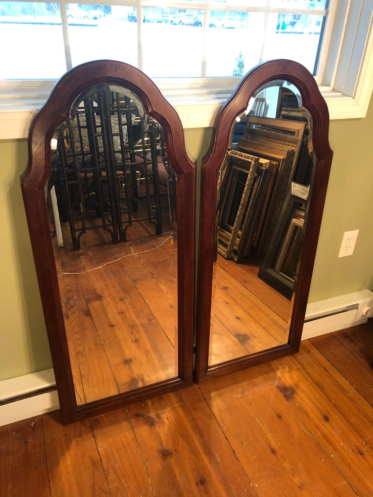 Pair of beveled arched mirrors. Made of a mahogany wood. Nice one inch bevel to the mirror. Perfect for over a bathroom vanity.
