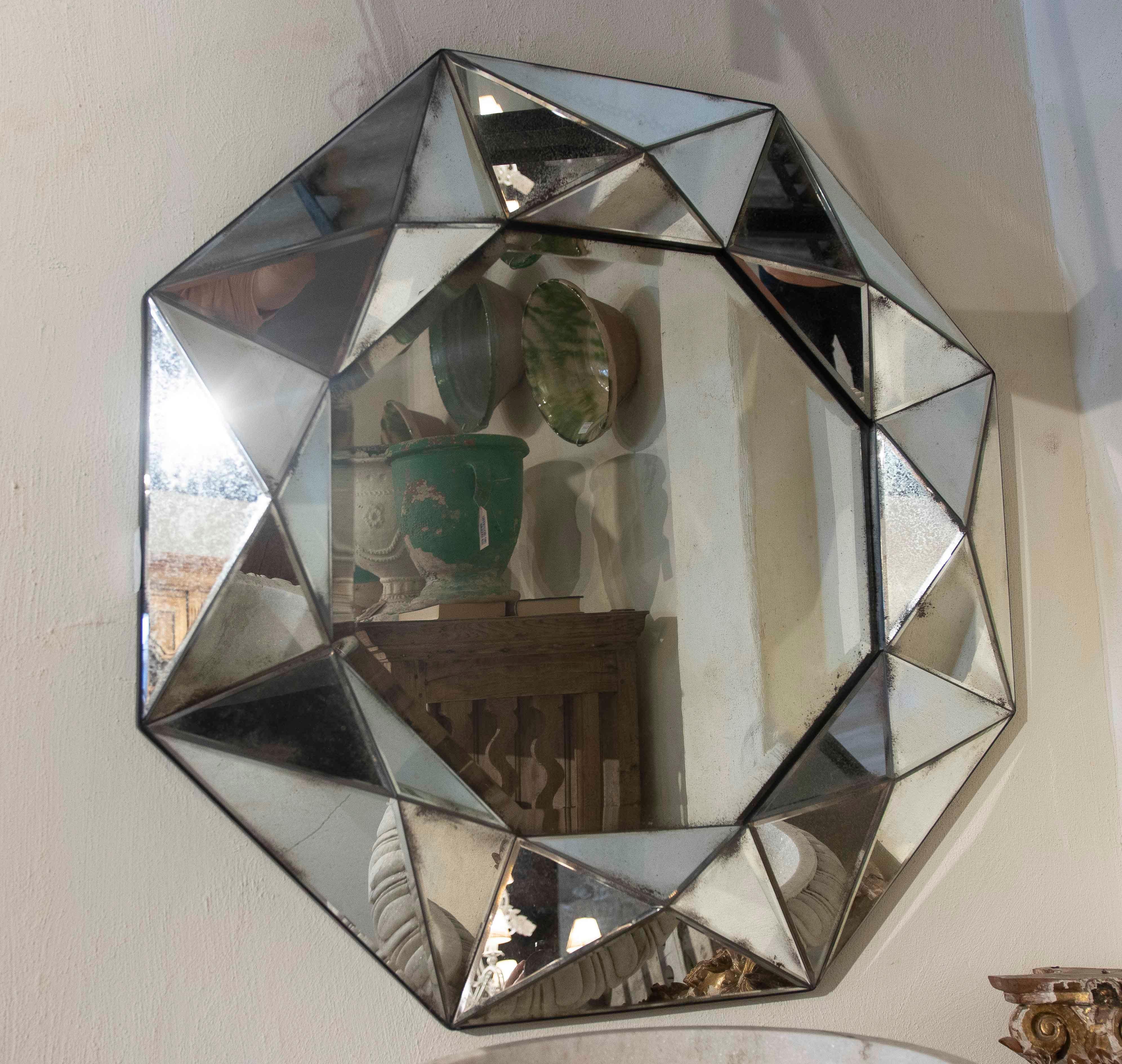 Un impresionante par de espejos octogonales con un marco compuesto por piezas de cristal biselado en forma de facetas geométricas. Cada espejo presenta un diseño tridimensional que recuerda el corte de una piedra preciosa, añadiendo profundidad,