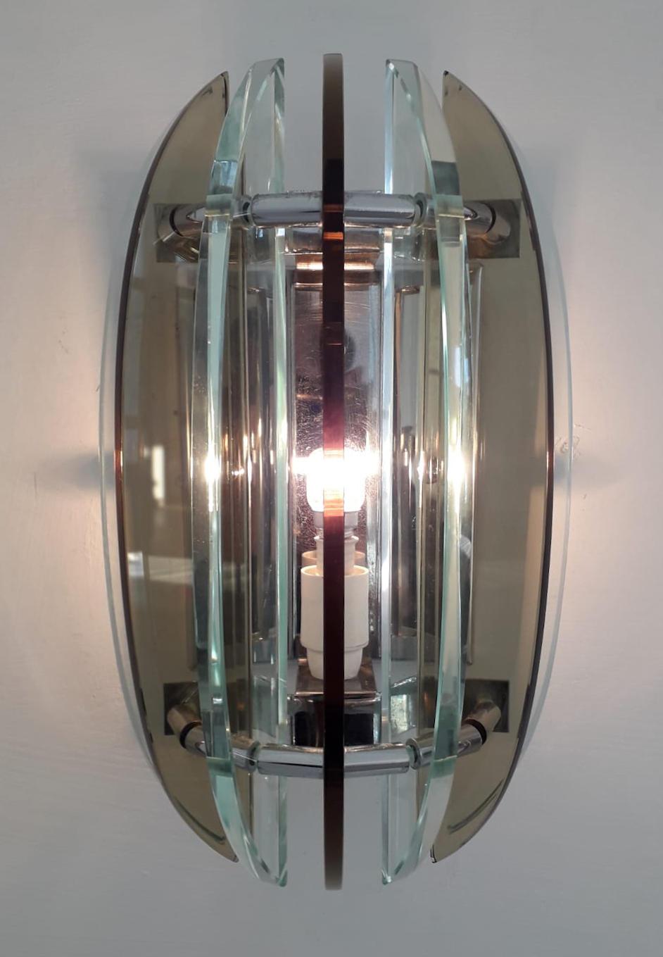 Paar italienische Wandleuchten mit klarem und rauchbraunem, abgeschrägtem Glas auf Nickelrahmen / Made in Italy by Veca, ca. 1960er Jahre.
1 Leuchte / Typ E12 oder E14/ max. 40W
Maße: Höhe 11 Zoll, Breite 7 Zoll, Tiefe 5 Zoll
Bestellnummer: FABIOLTD