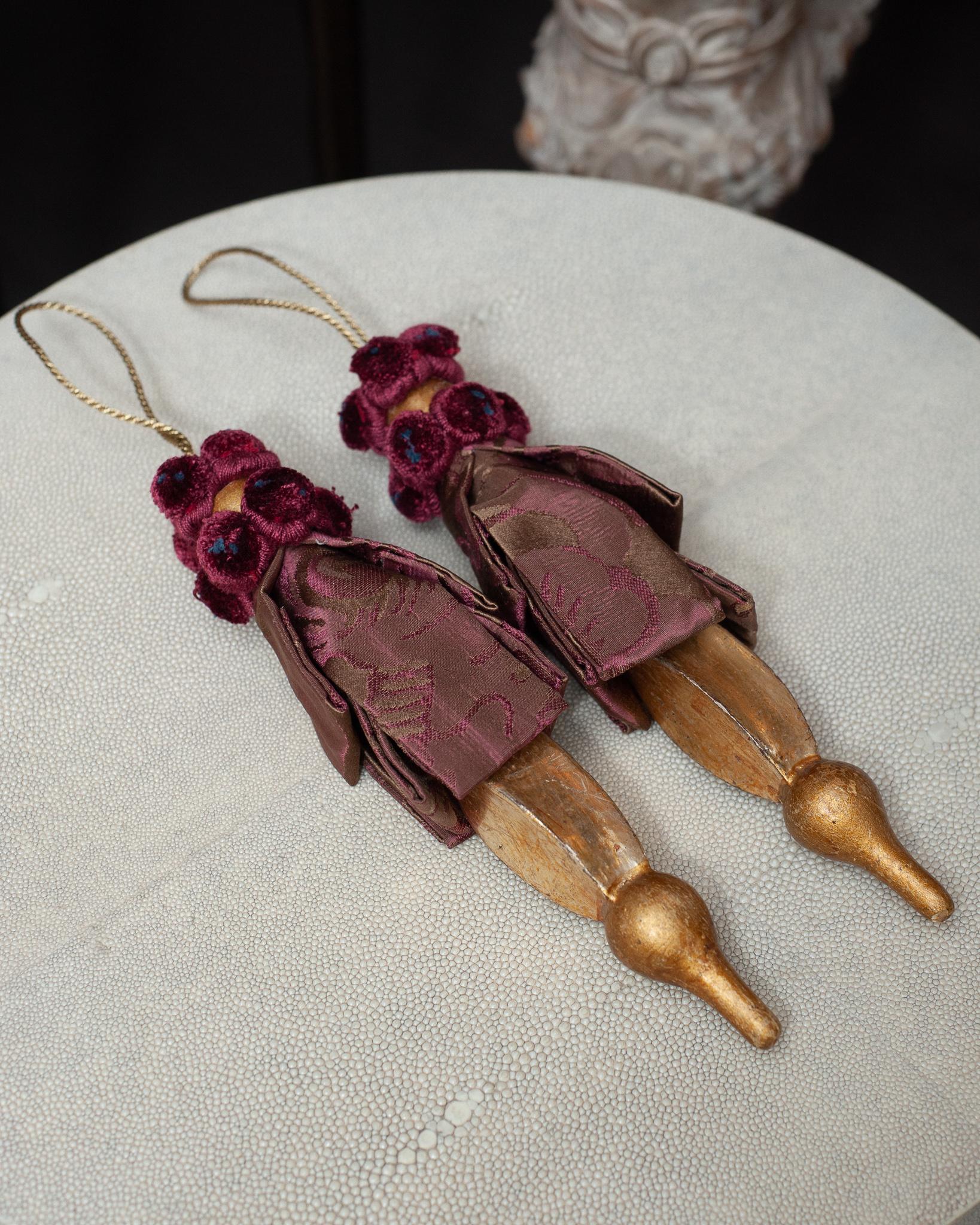 A gorgeous pair of hand carved gilt wood and silk damask tassels, from Bevilacqua Italy. Established by Luigi Bevilacqua, and operating out of Venice since 1875, Bevilacqua Tessuti produces the most exquisite handwoven fabrics available out of
