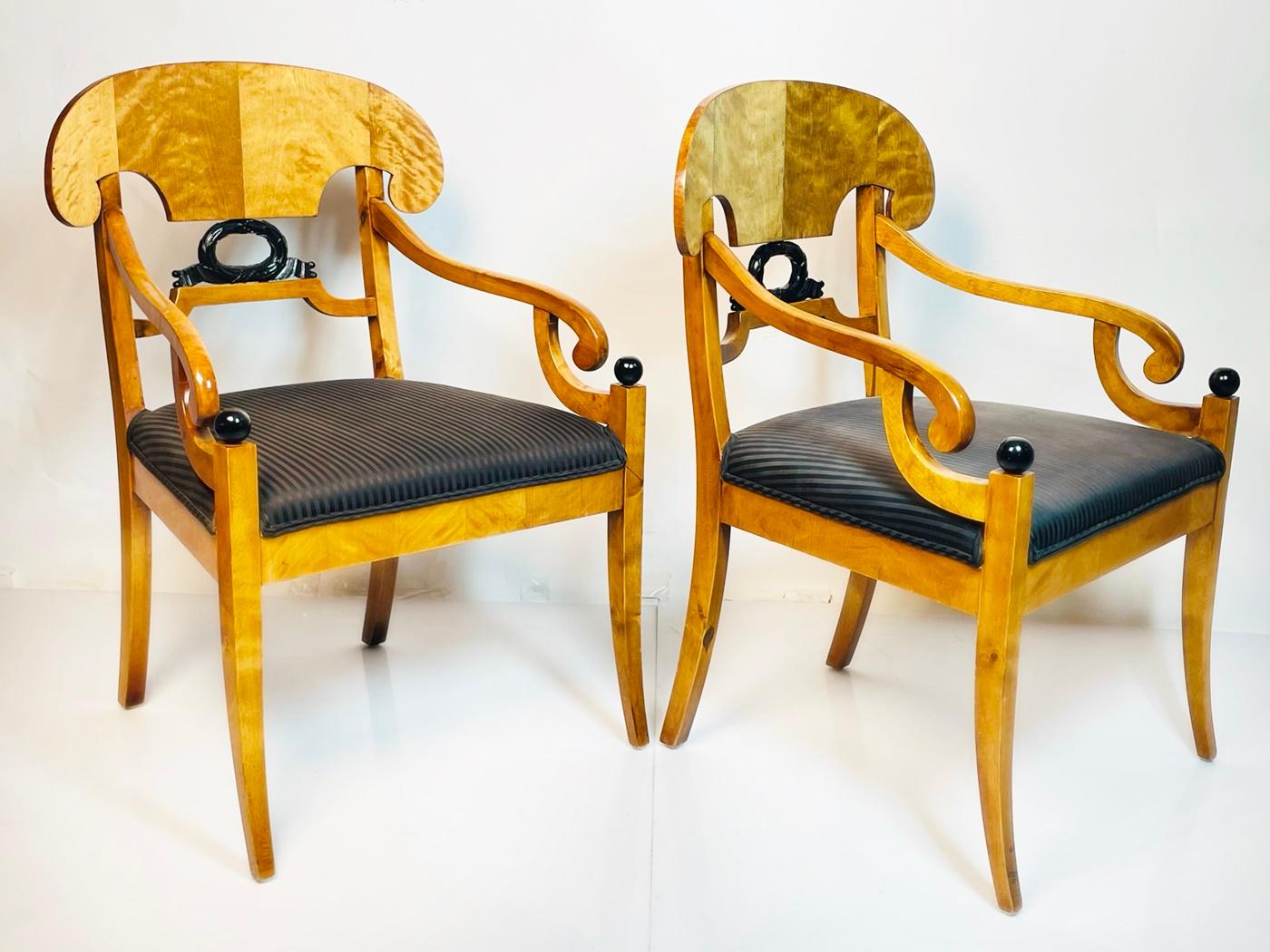 Introducing a timeless piece of furniture that effortlessly blends elegance and functionality - the Pair of Biedermeier Arm Chairs in Flame Birch Wood, hailing from Sweden in the 1900s. Crafted with exquisite attention to detail, these chairs