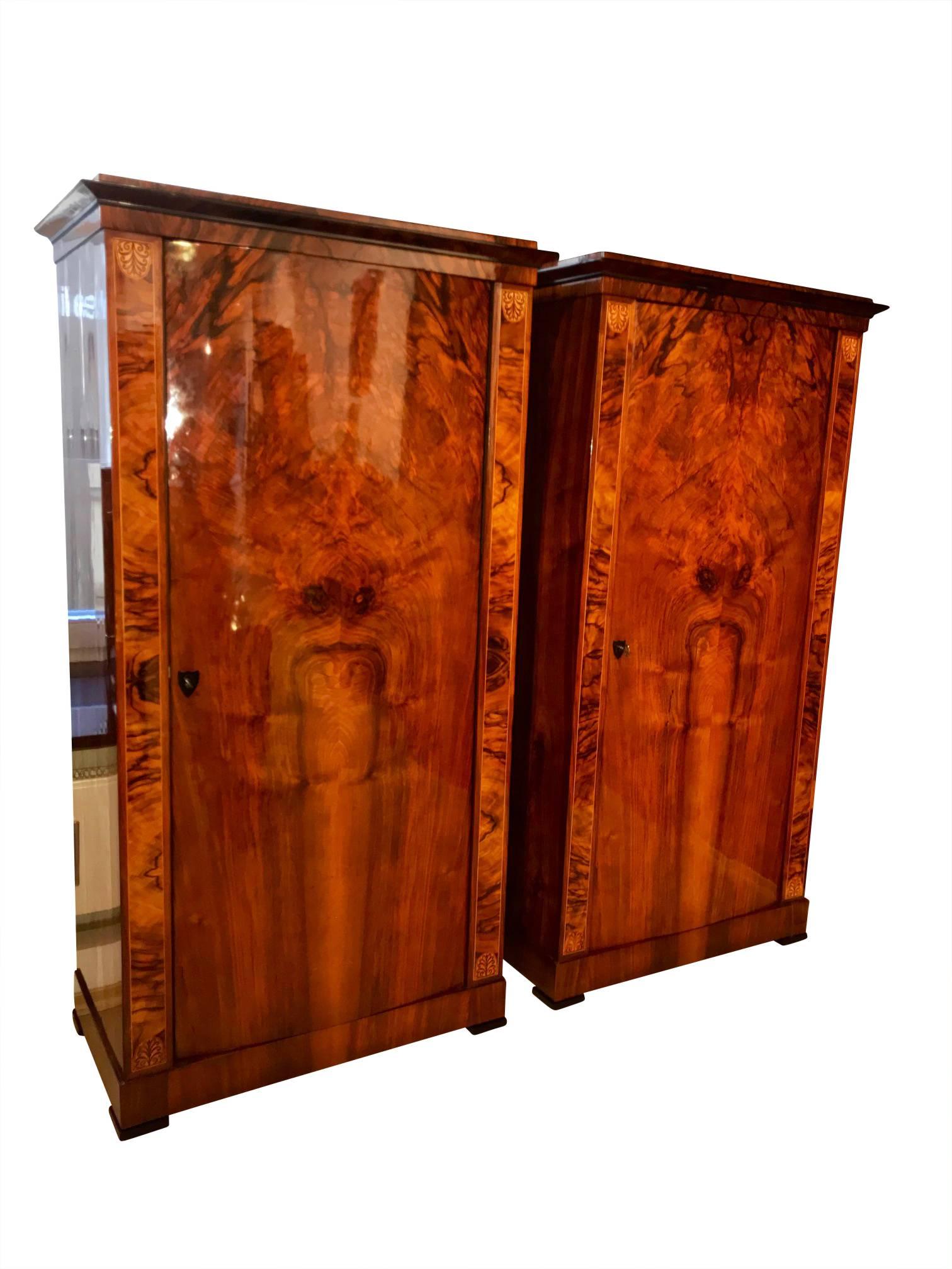 Beautiful Pair of one doored neoclassical Biedermeier Armoires / Wardrobes from Austria around 1830.

Wonderful lightly convex doors and finely book-matched walnut veneer on the front and sides. Finished with a very elaborate shellac hand polish