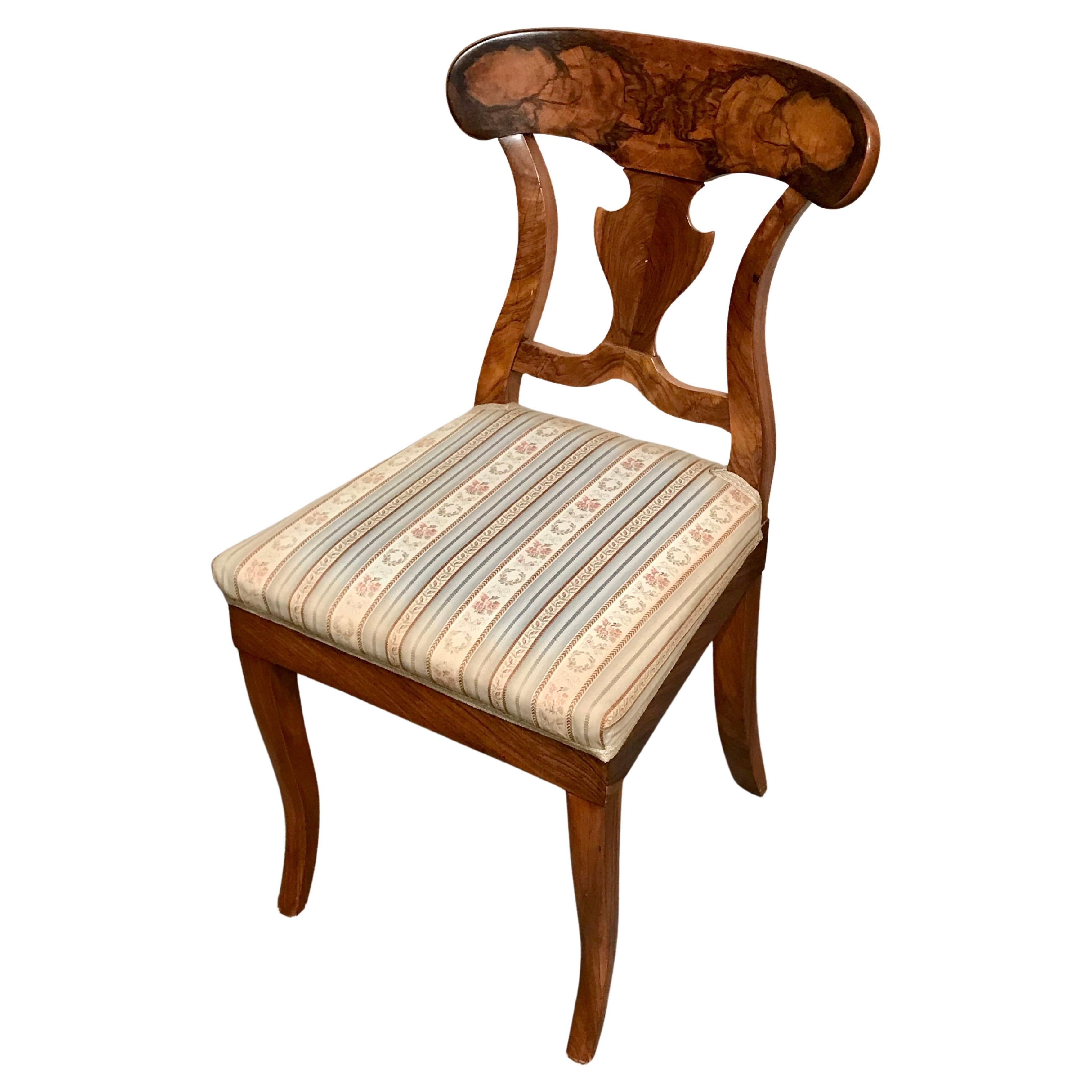 Pair of Biedermeier chairs, South West Germany 1820, walnut veneer. Original pair of Biedermeier chairs with a nicely designed back which features a beautiful walnut veneer grain.  The chairs are in good original condition. On the bottom of the