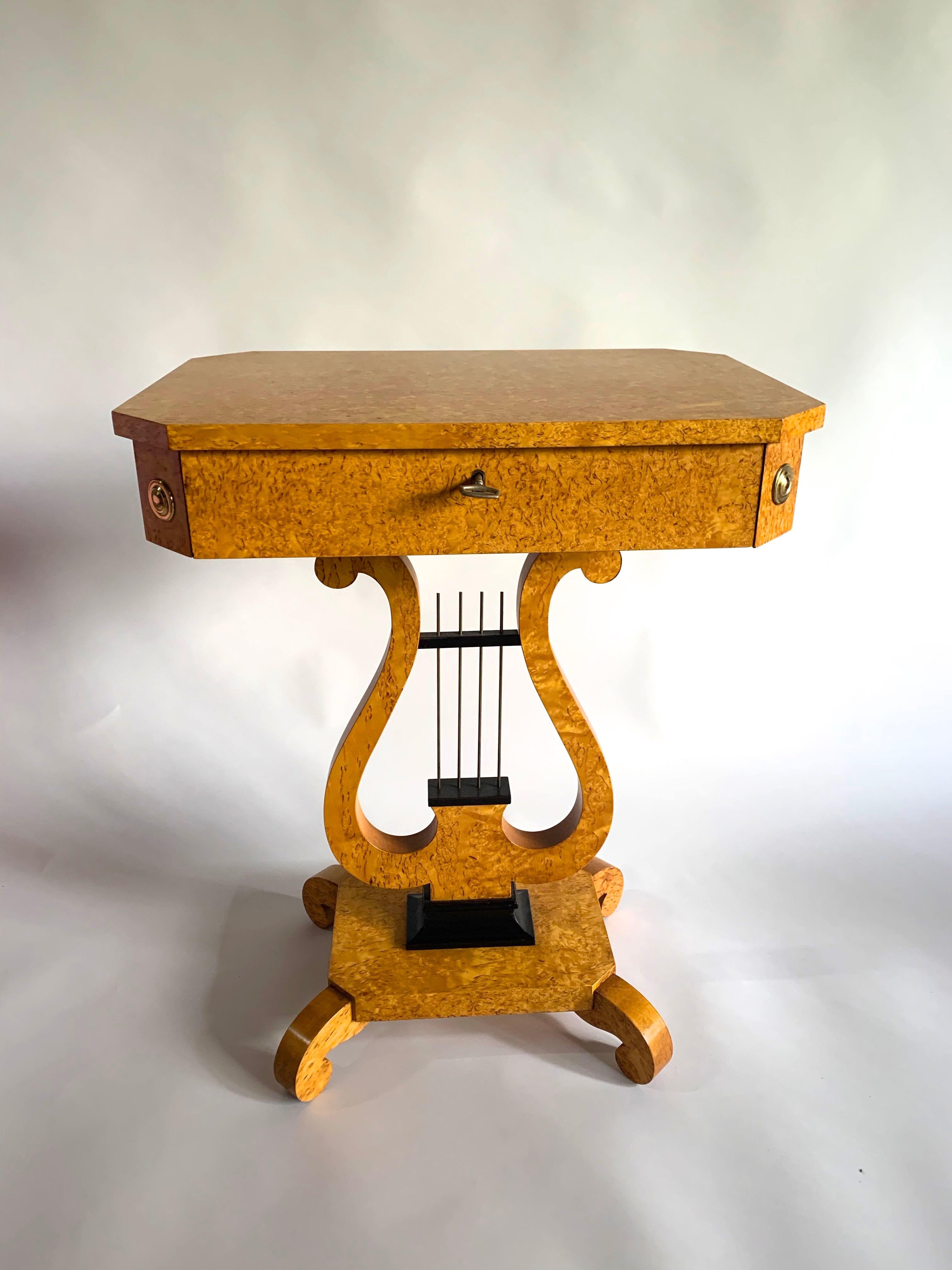 A rare pair of Karelian birch Swedish Lyre sewing tables. The tables have an exceptionally good grain and color to the timber. They are mounted with brass pateries, the central strings of the Lyre are brass.
Ebonized detailing to the base. The