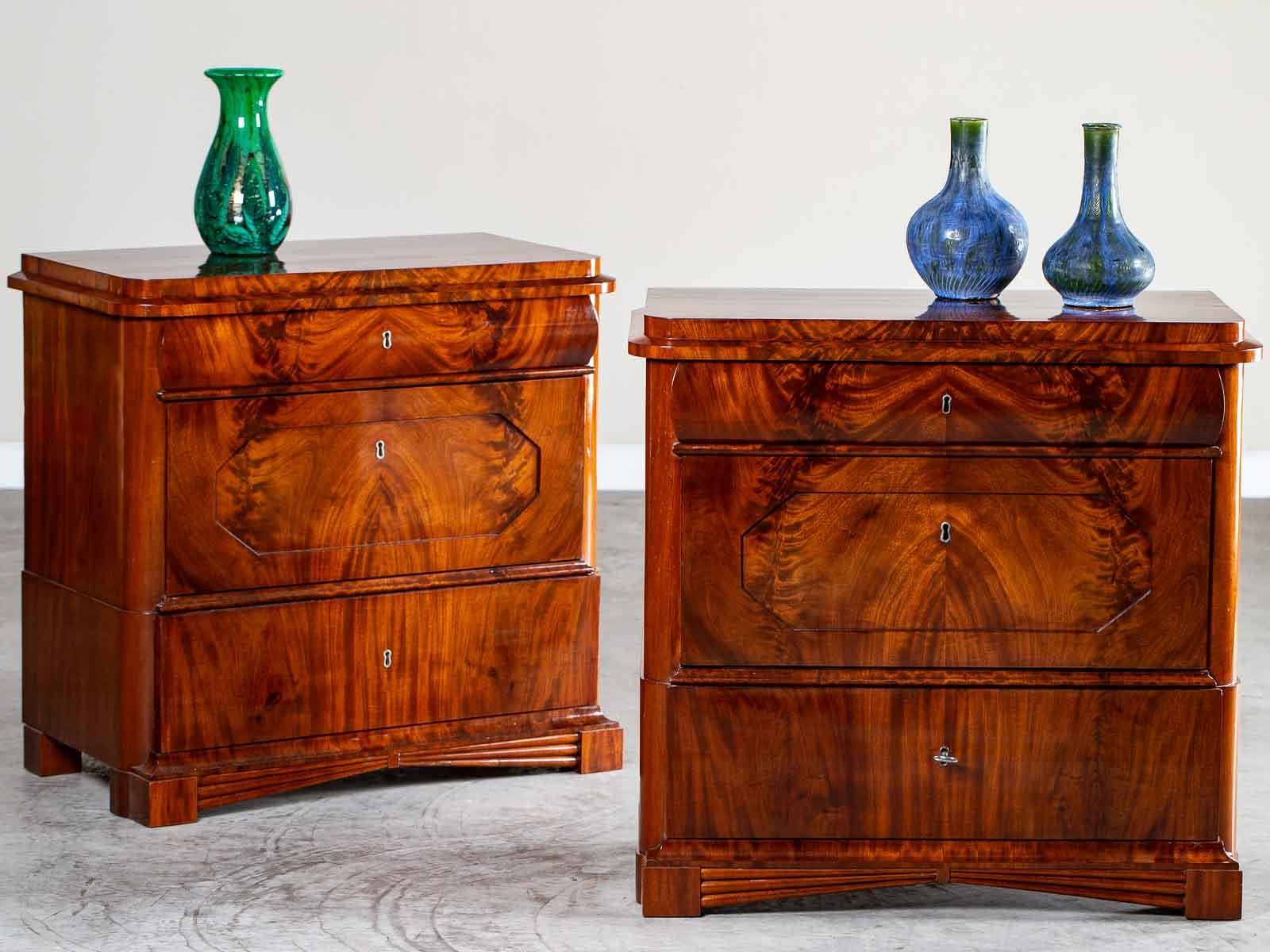 A pair of Biedermeier period mahogany chests from North Germany, circa 1820. The distinctive shape of this pair of antique chests reflect the architectural styling notable during the early part of the nineteenth century. Fashioned entirely of