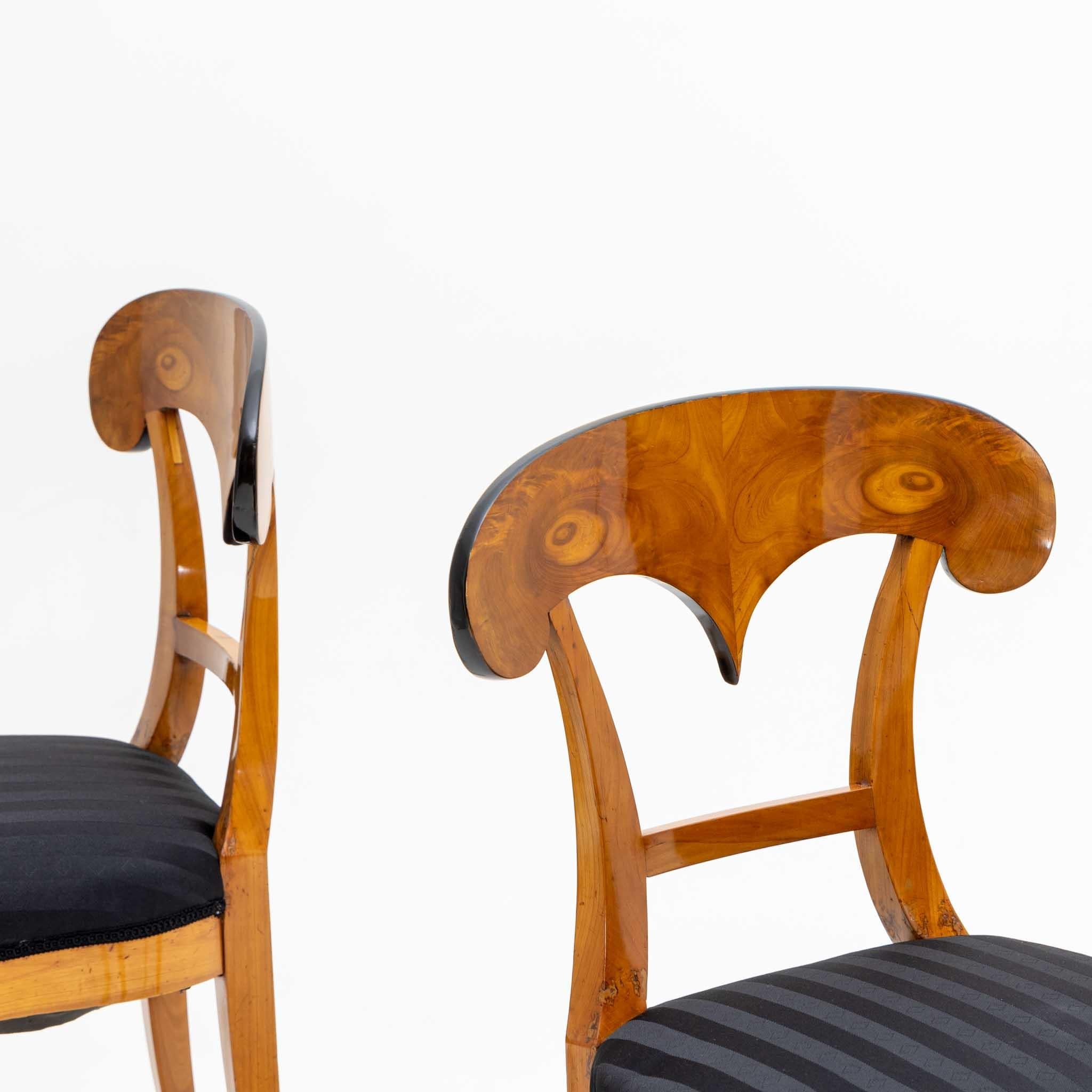 Pair of South German shovel chairs made of solid and veneered cherry wood. The shovel-shaped backs are symmetrically veneered and form a deep point downwards. The chairs have been newly upholstered in a black striped fabric and were completely hand