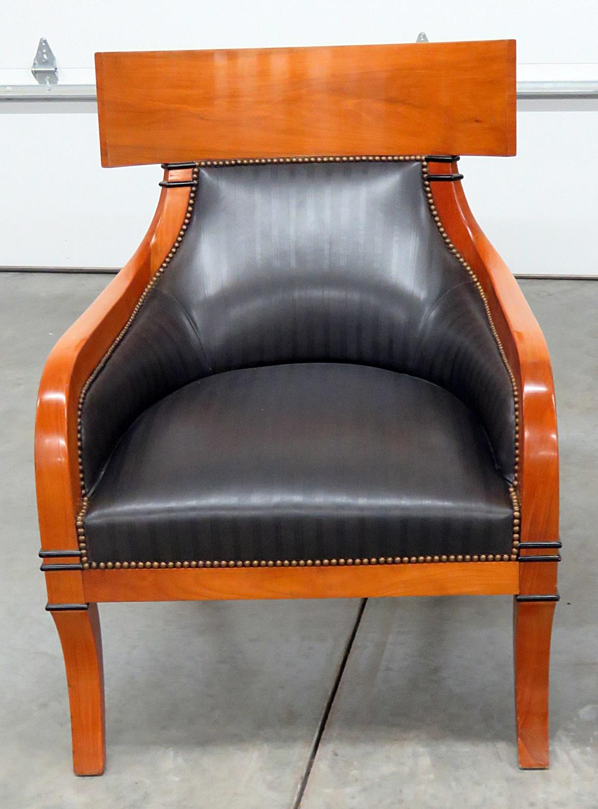 Pair of Biedermeier style leather upholstered club chairs with nailhead trim and ebonized accents.