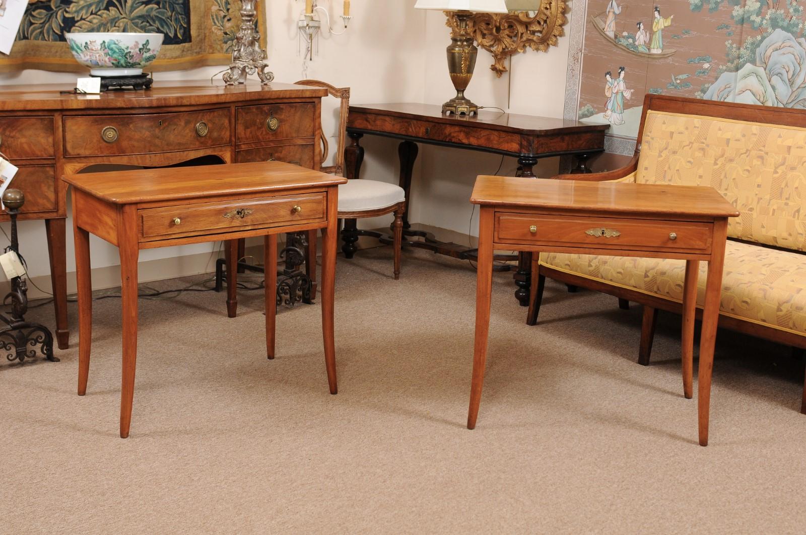 A pair Biedermeier style fruitwood side tables with drawer in frieze with brass pulls and tapered splayed legs. The tables dating from the late 19th century.