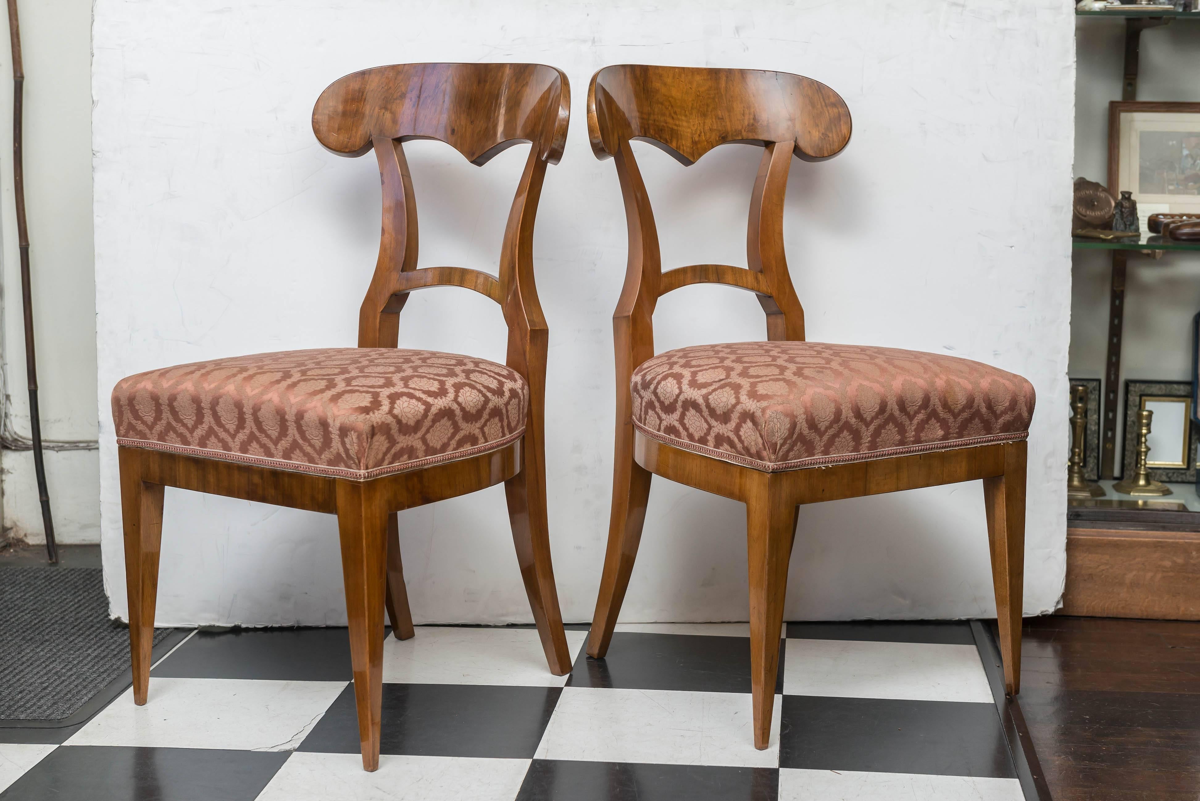 Pair of Biedermeier walnut side chairs. Beautiful shape and proportions. Old walnut with a polished and waxed finish, 1920s-1930s fine brocade upholstery, having some wear on the edges and a few stains on one seat.
Elegant and classic early period