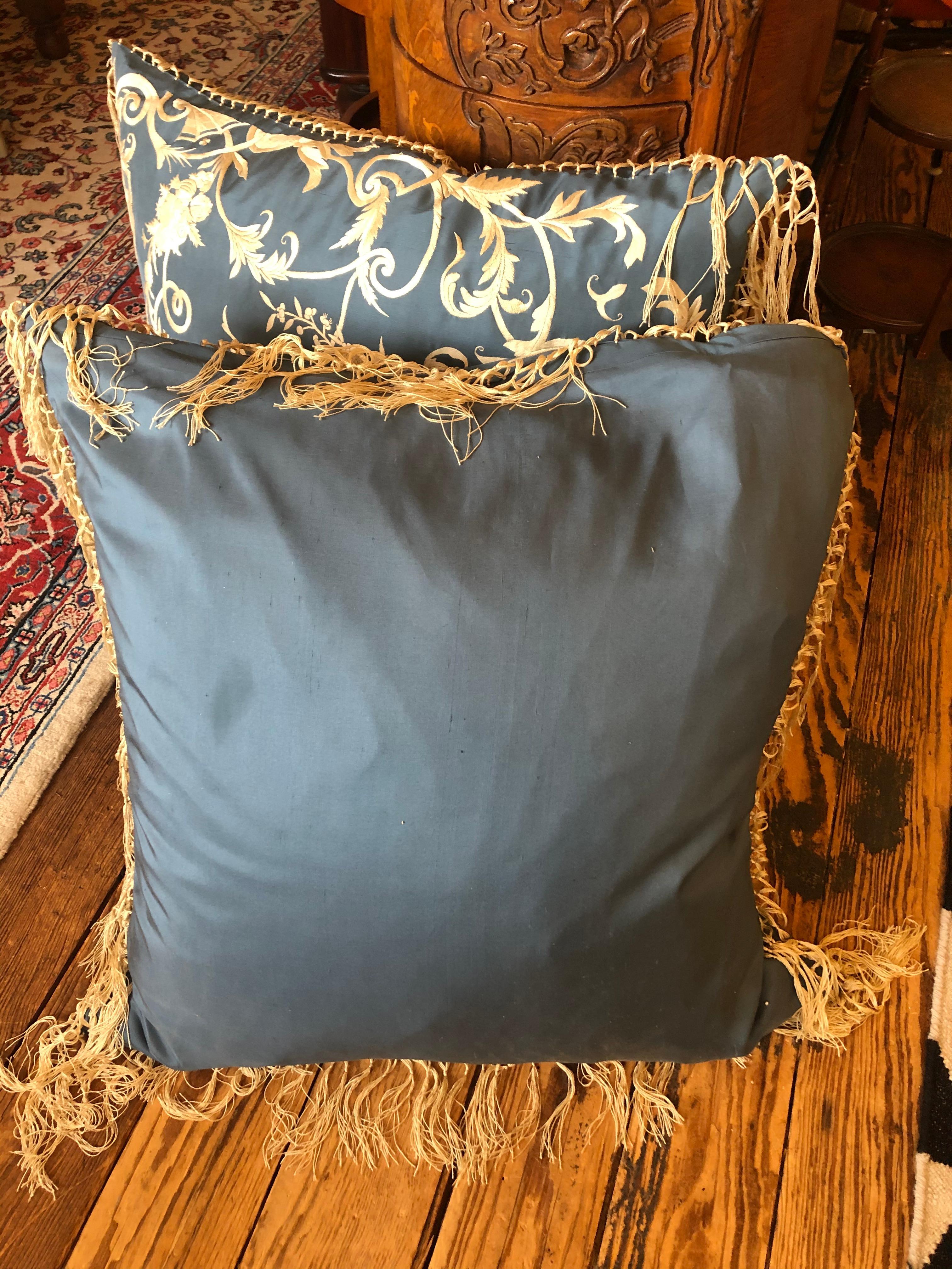 A sumptuous down filled silk pillow by Ralph Lauren in a soothing shade of periwinkle blue with cream embroidery and fringe.