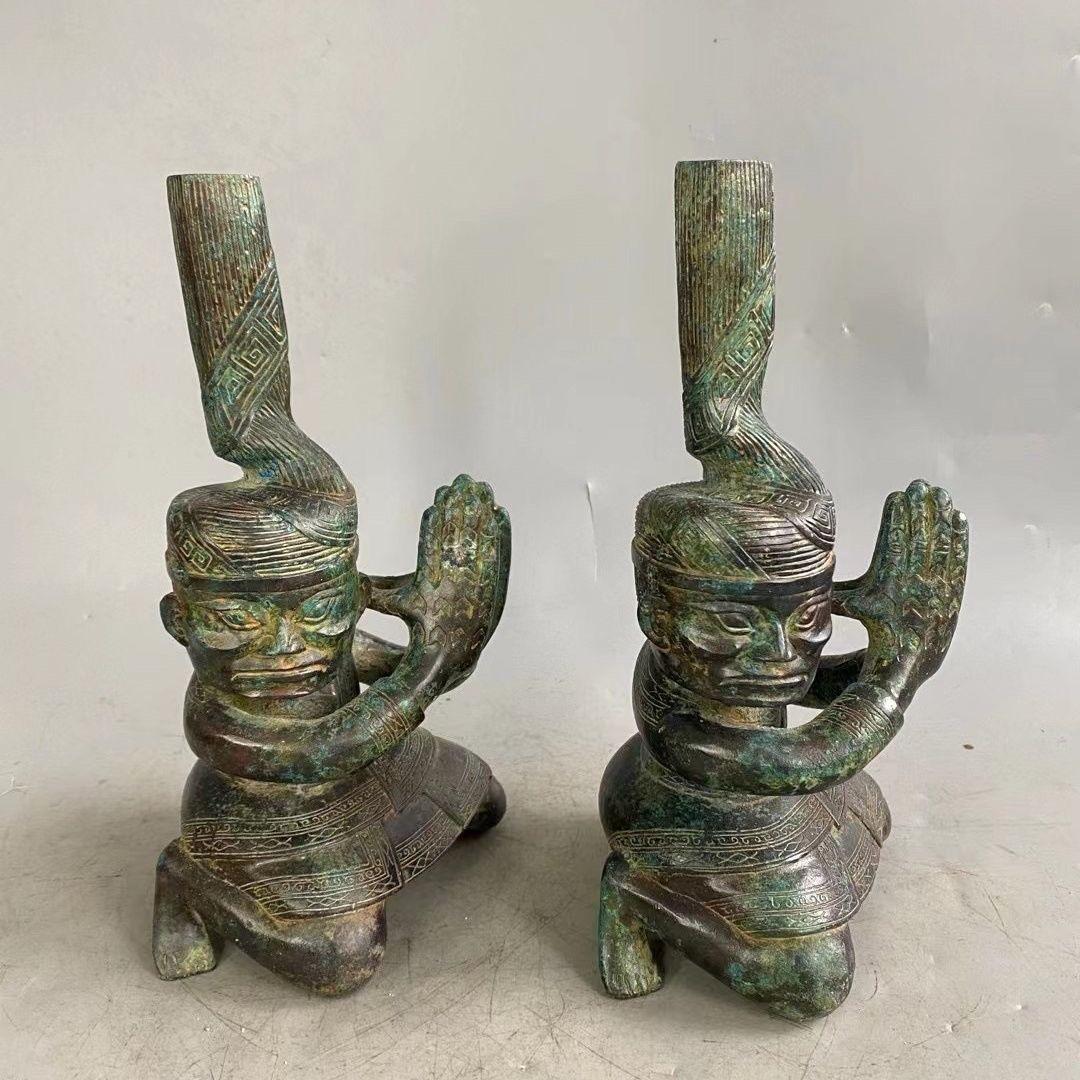 La statua cinese in bronzo antico che batte le mani inginocchiandosi è un manufatto affascinante e culturalmente significativo, potenzialmente rappresentativo delle pratiche cerimoniali o religiose dell'antica Cina. 

L'atto di inginocchiarsi è