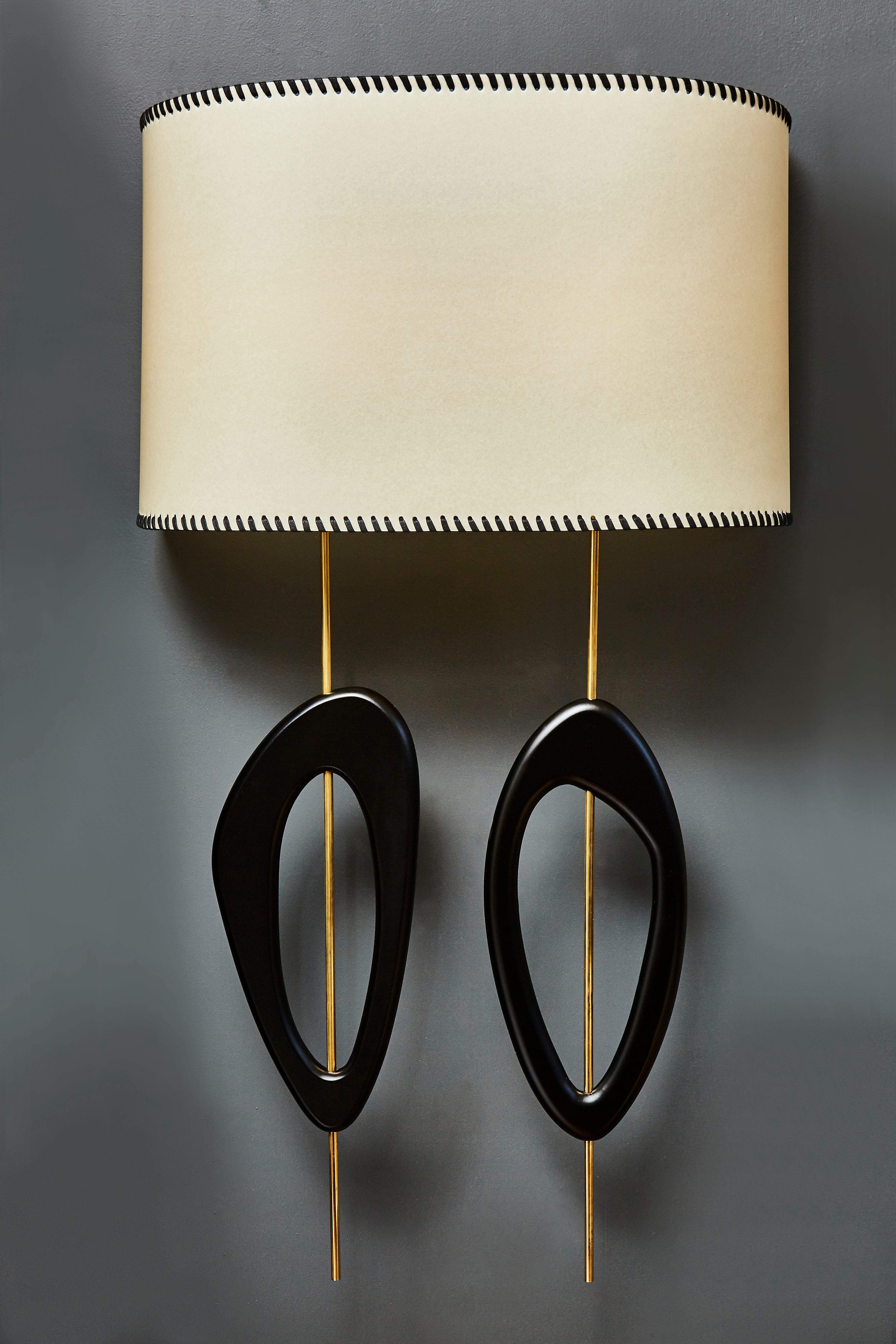 Pair of big and elegant wall sconces by the artist Diego Mardegan for Glustin Luminaires.

Two floating brass rods holding painted wood decors and a parchment paper shade handwoven with waxed fabric.