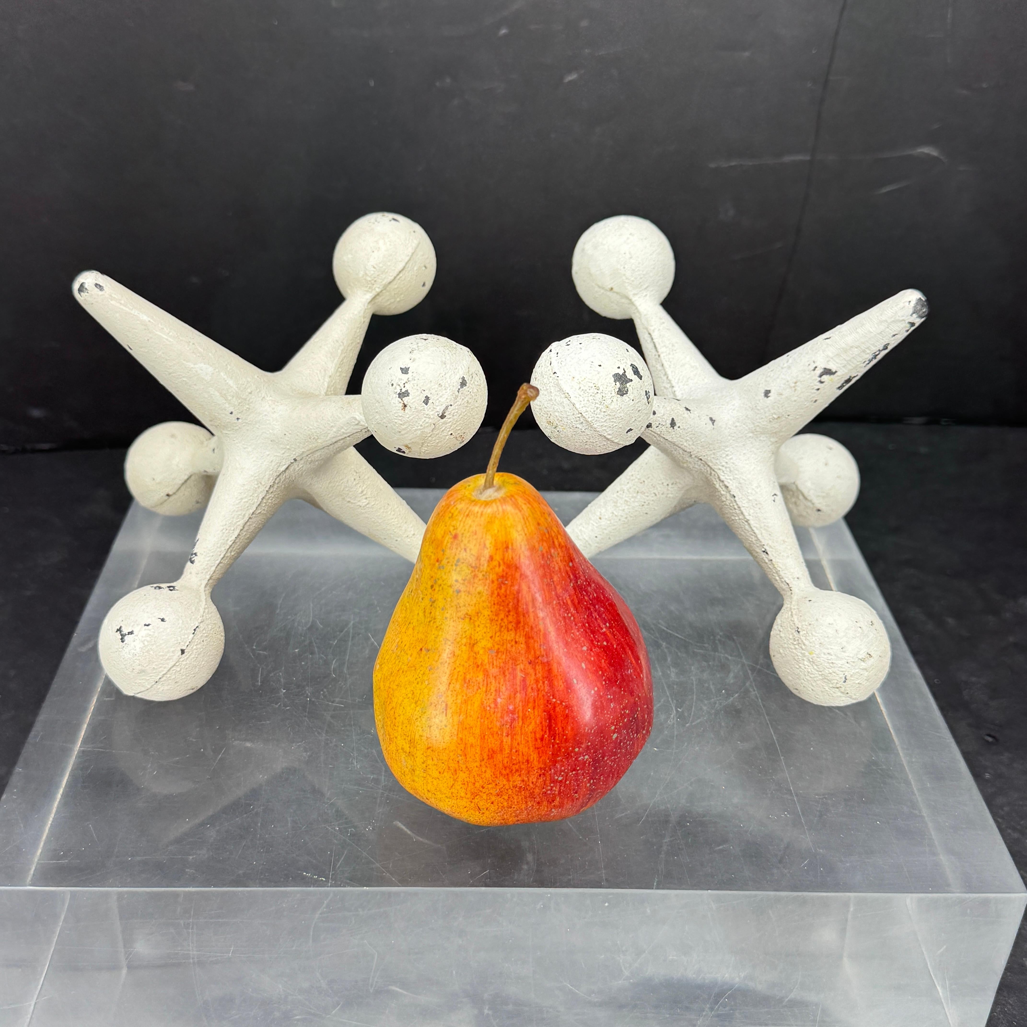 This heavy set of Mid-Century Modern Jacks bookends or doorstops are made by Bill Curry for Design Line. This pair of white painted bronze in nice age appropriate patinated white color, slight wear and chips on the painting that gives character.
 