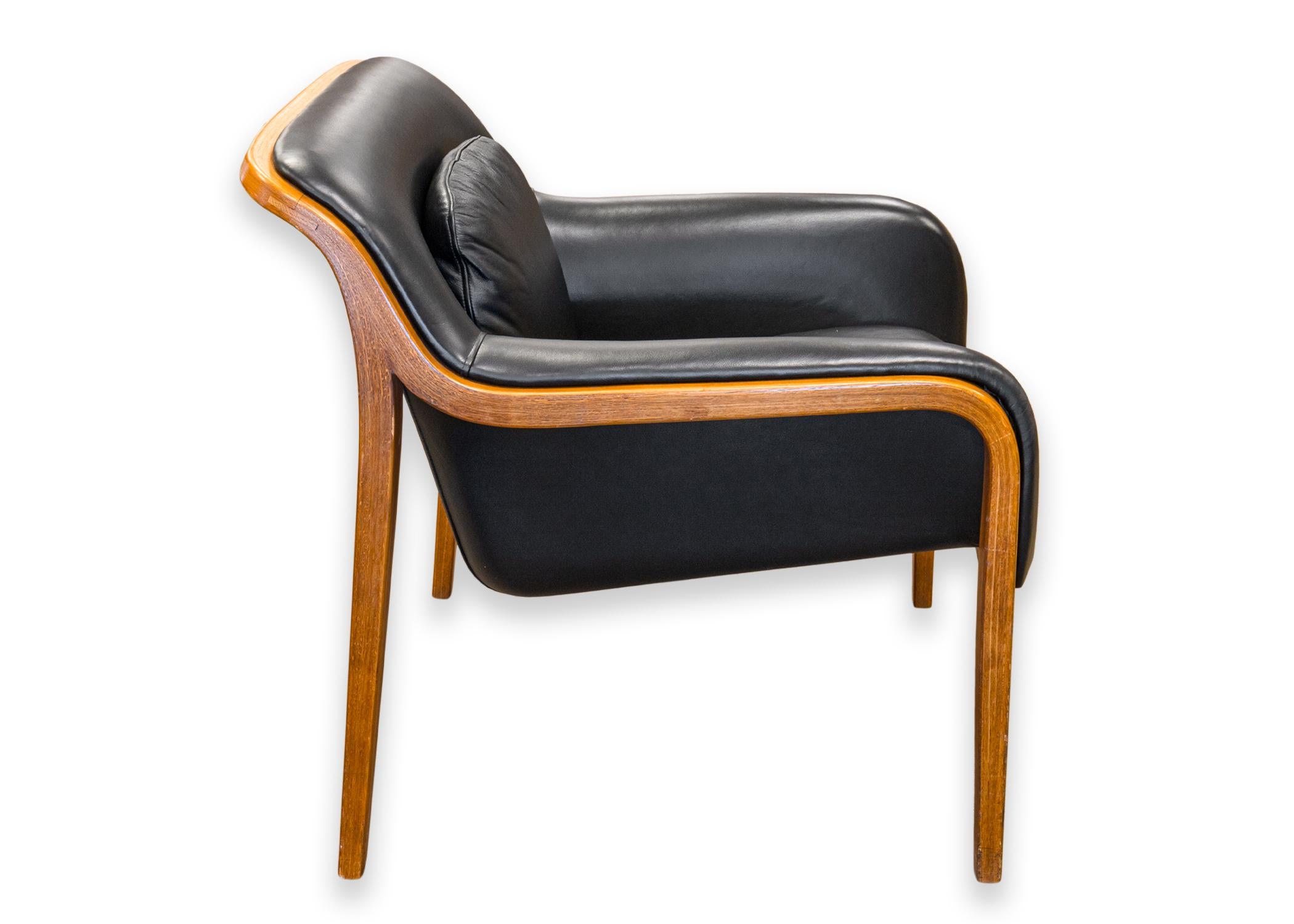 A set of Bill Stephens for Knoll accent armchairs. A gorgeous mid century modern set of accent armchairs with a wooden frame, and a rich black leather upholstery. These chairs feature four rectangular wooden legs that bend and curve into the frame