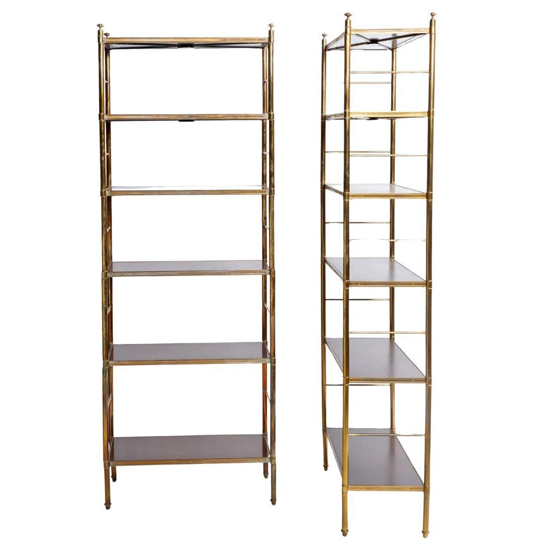 A pair of Billy Baldwin style etageres crafted of brass frames and mahogany shelves.  Each piece is fitted with six mahogany shelves supported by a brass rounded frame with X supports beneath.  Fnished with finials at each top corner.