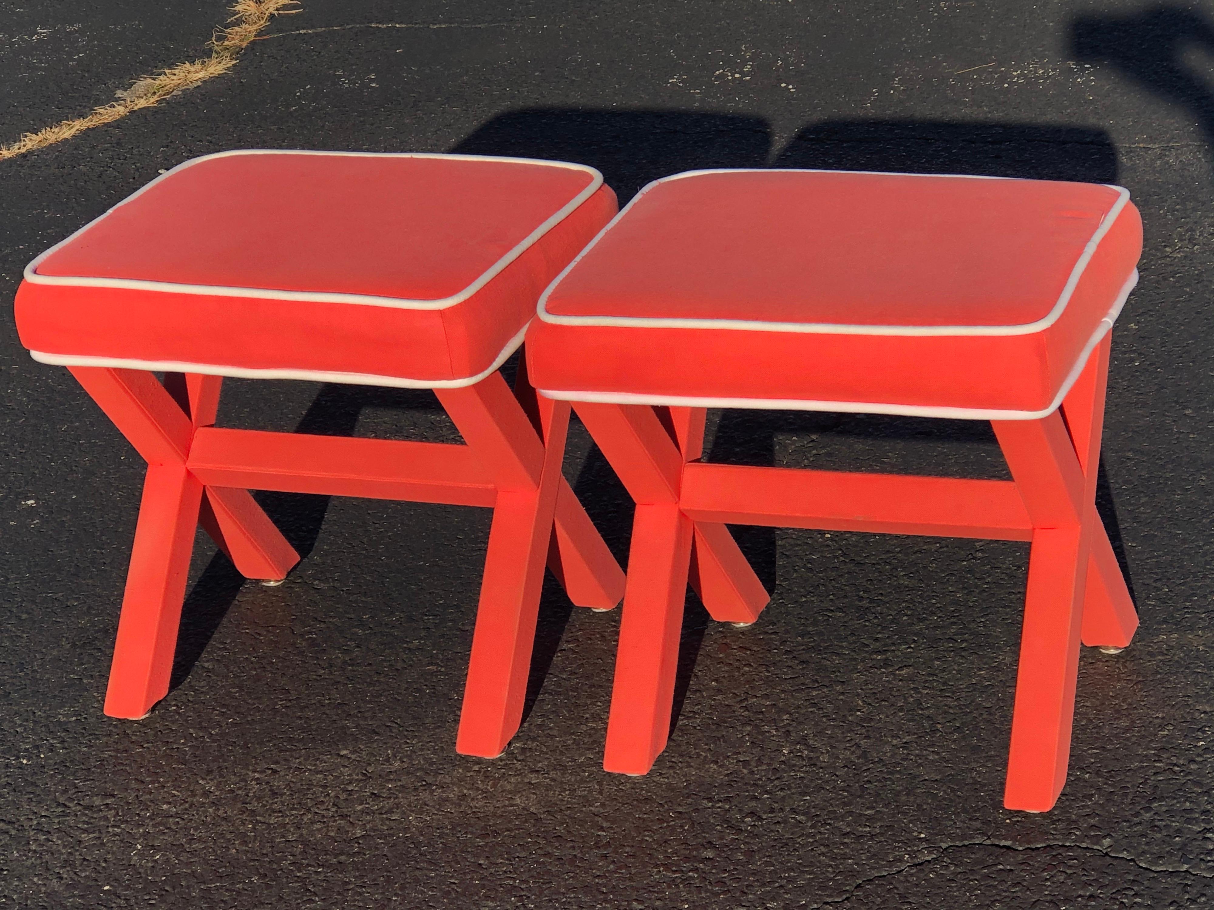 Pair of Billy Baldwin style X base stools. Hot pink/salmon color with white piping. Perfect for under a console table or in a bedroom. This item will parcel ship for $75