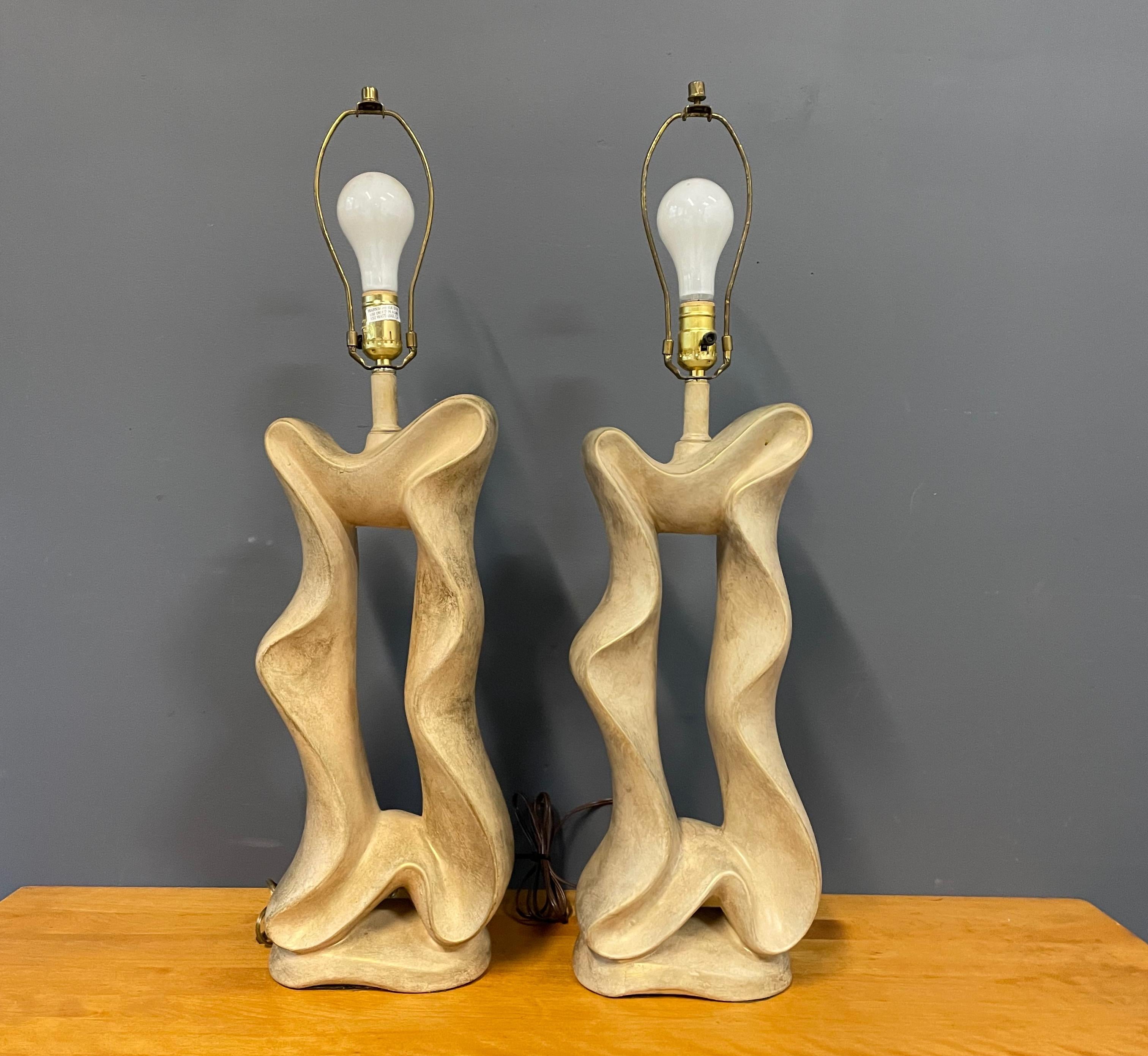 Pair of unusual, ceramic lamps in a ribbon form in a neutral color with a gold wash produced by Jaru.