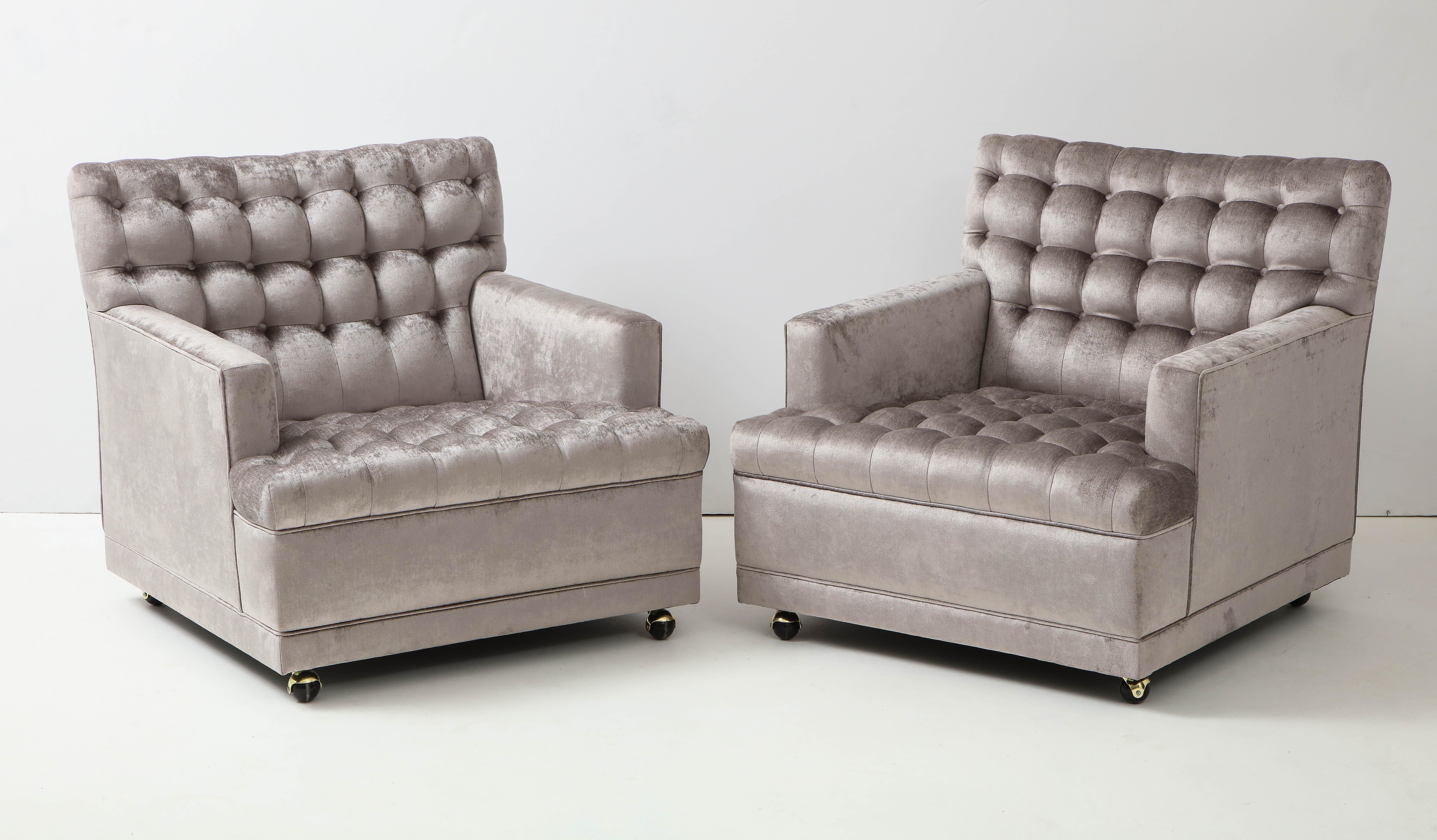 Stunning pair of club chairs .
The chairs have been beautifully reupholstered with a biscuit tufted seat and back in a luxurious silk velvet fabric. 
The chairs are on casters and they each have a separate accent pillow.