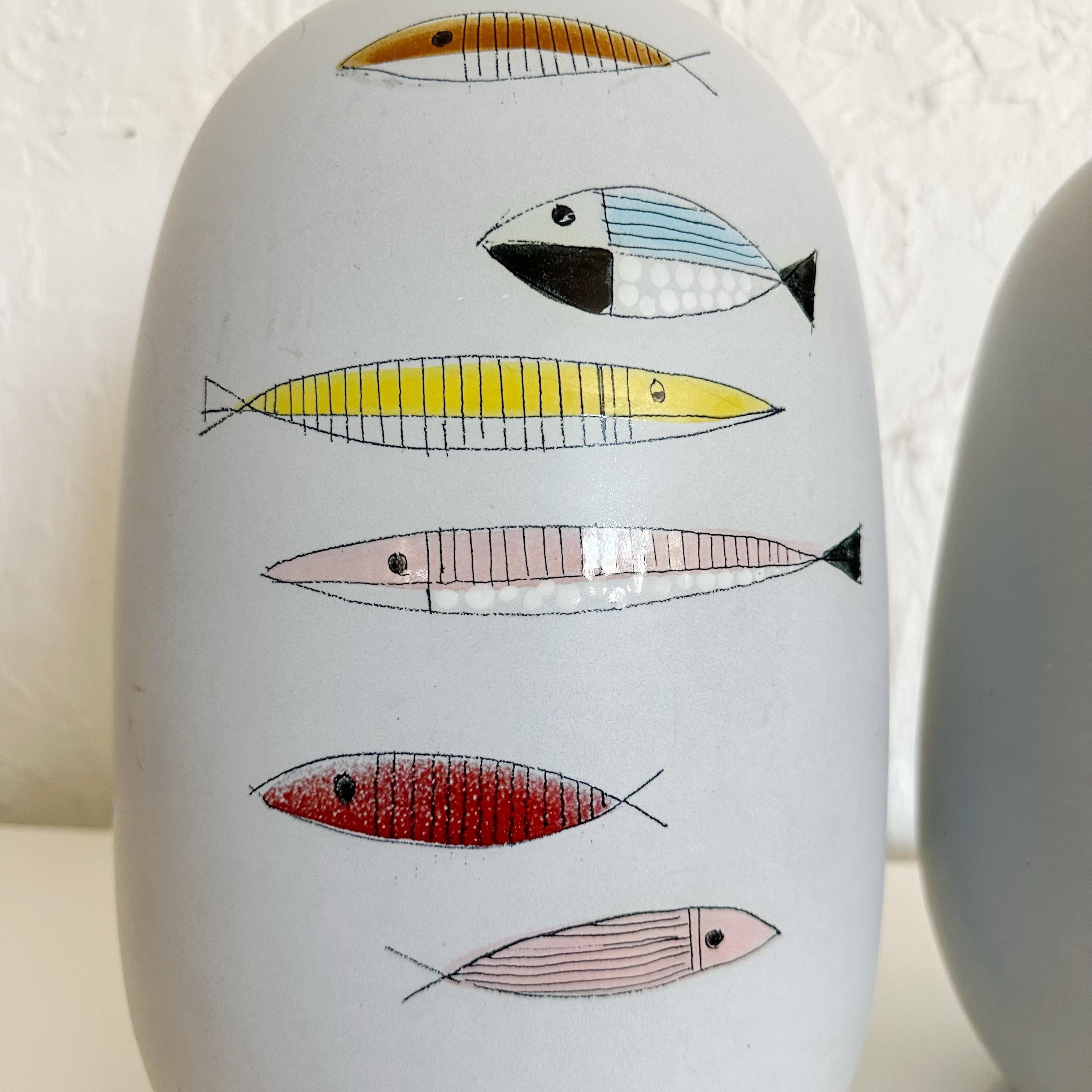 Pair of Bitossi Ceramic Fish Lamps for Raymor, Italy, 1950s. These lamps are hand made and a slight variation in size. Both lamps match hand painted glazed fish patterns. They have been professionally rewired with a cream French silk twist cord.