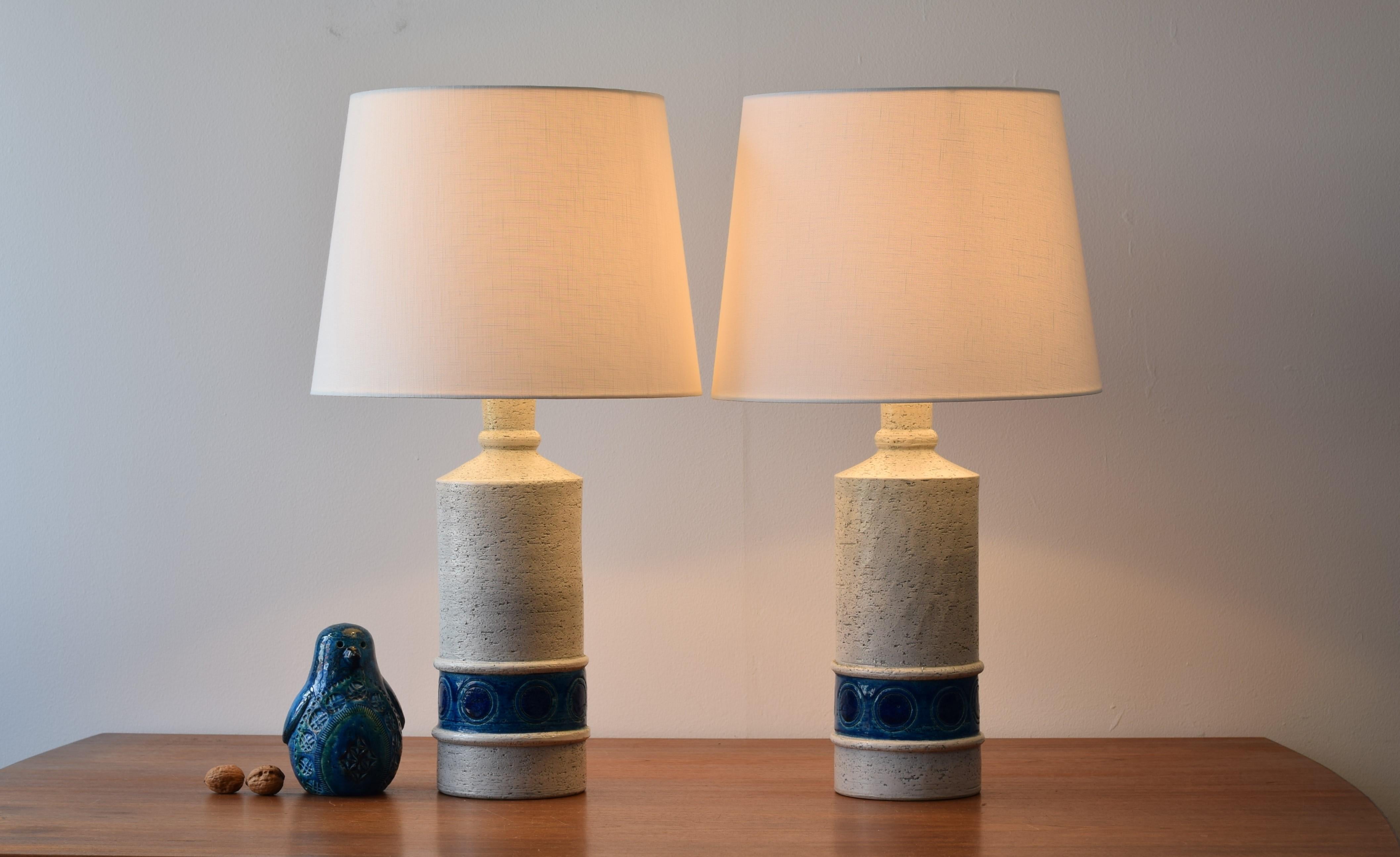 Pair of vintage Bitossi lamps including new quality lampshades!

They have a rough white surface with a turquoise and blue circle decor.

The lampshades are designed in Denmark and made of woven fabric with some texture and are natural white.
