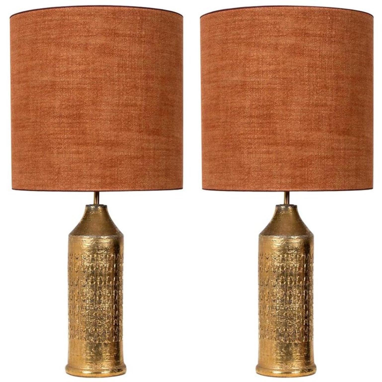 Pair of table lamps. Each lamp features a ceramic base with a rough surface in an off-white glaze with shiny metallic gold glazed patterns, Bitossi, Italy, circa 1960s. With exceptional new custom made sil brique shades by René Houben. With warm