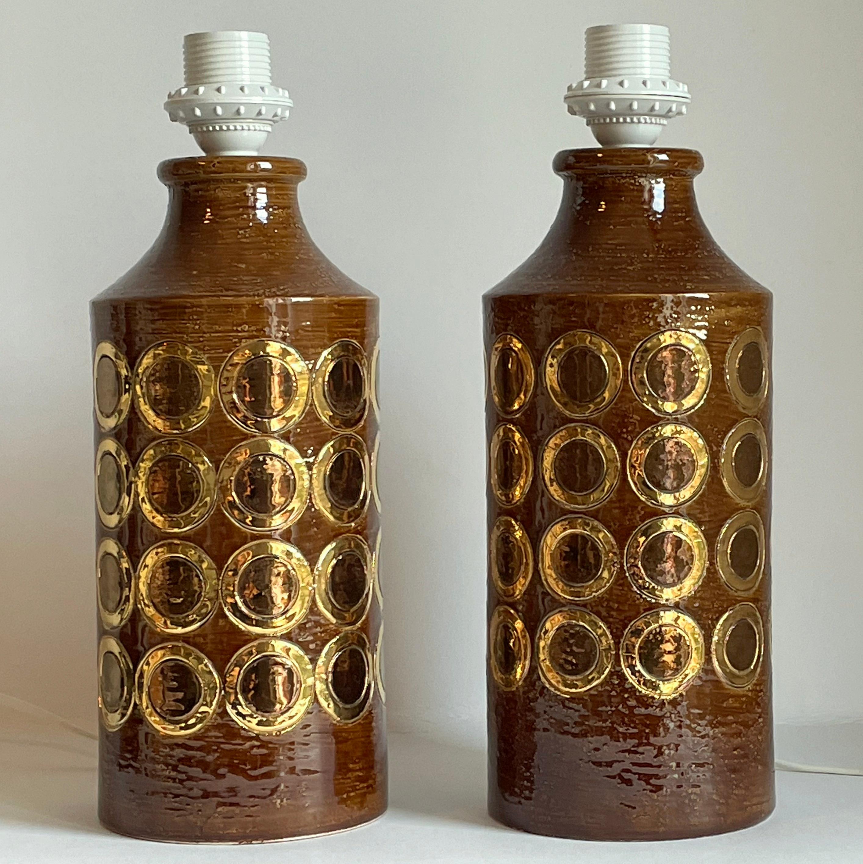 A rare pair of Italian ceramic table lamps by Bitossi. These lamps has beautiful circles glazed in gold and copper on a brown background. Excellent condition. Just rewired. 
Please note: We are selling these lamps without the lamp shades. 


